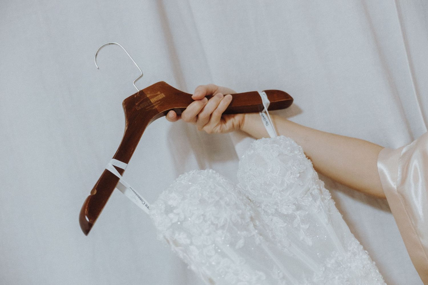 A collection of wedding dress details featuring lace, beading, and delicate fabric textures shown in multiple photos.