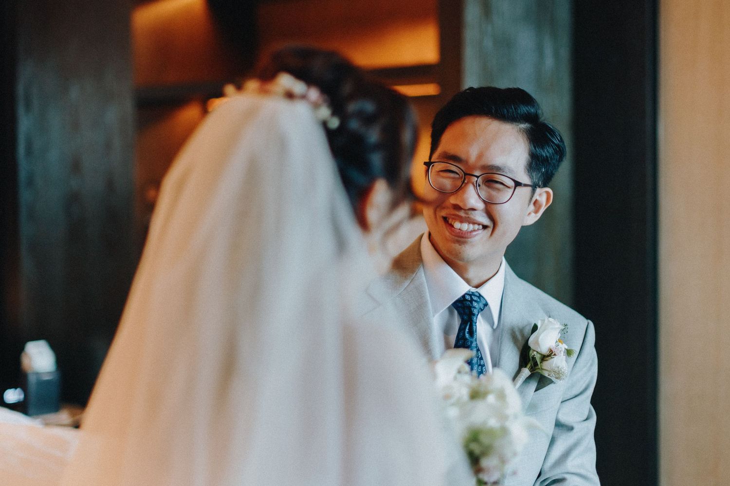 Joyful wedding day reactions photographed in elegant indoor venue.