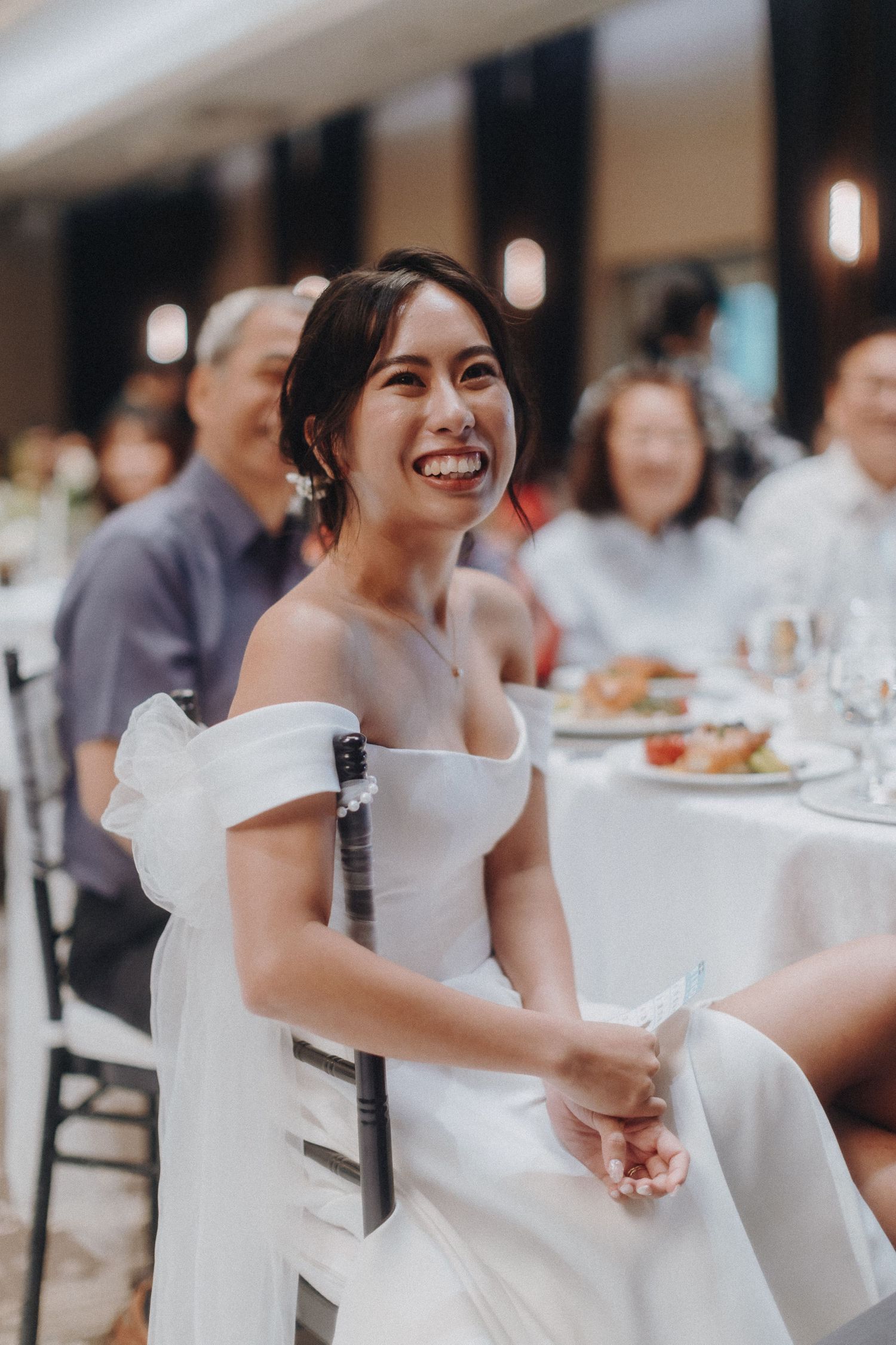 An elegant wedding reception with formal table settings and decorative lighting.