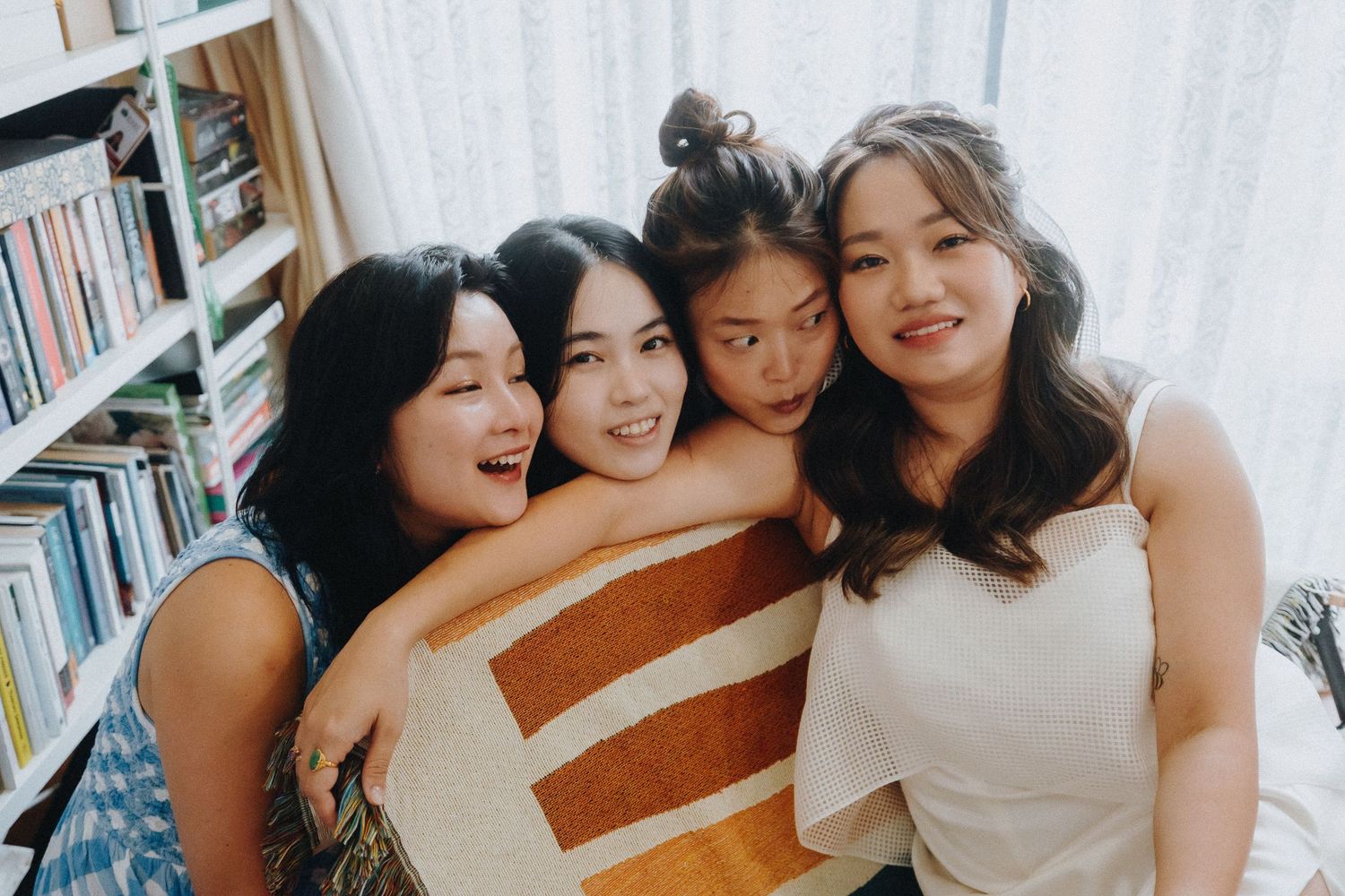 Group photo session on white stairs with bookshelves in the background.