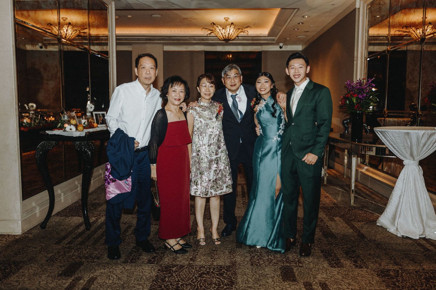 A formal group photo of elegantly dressed guests at an evening celebration event.