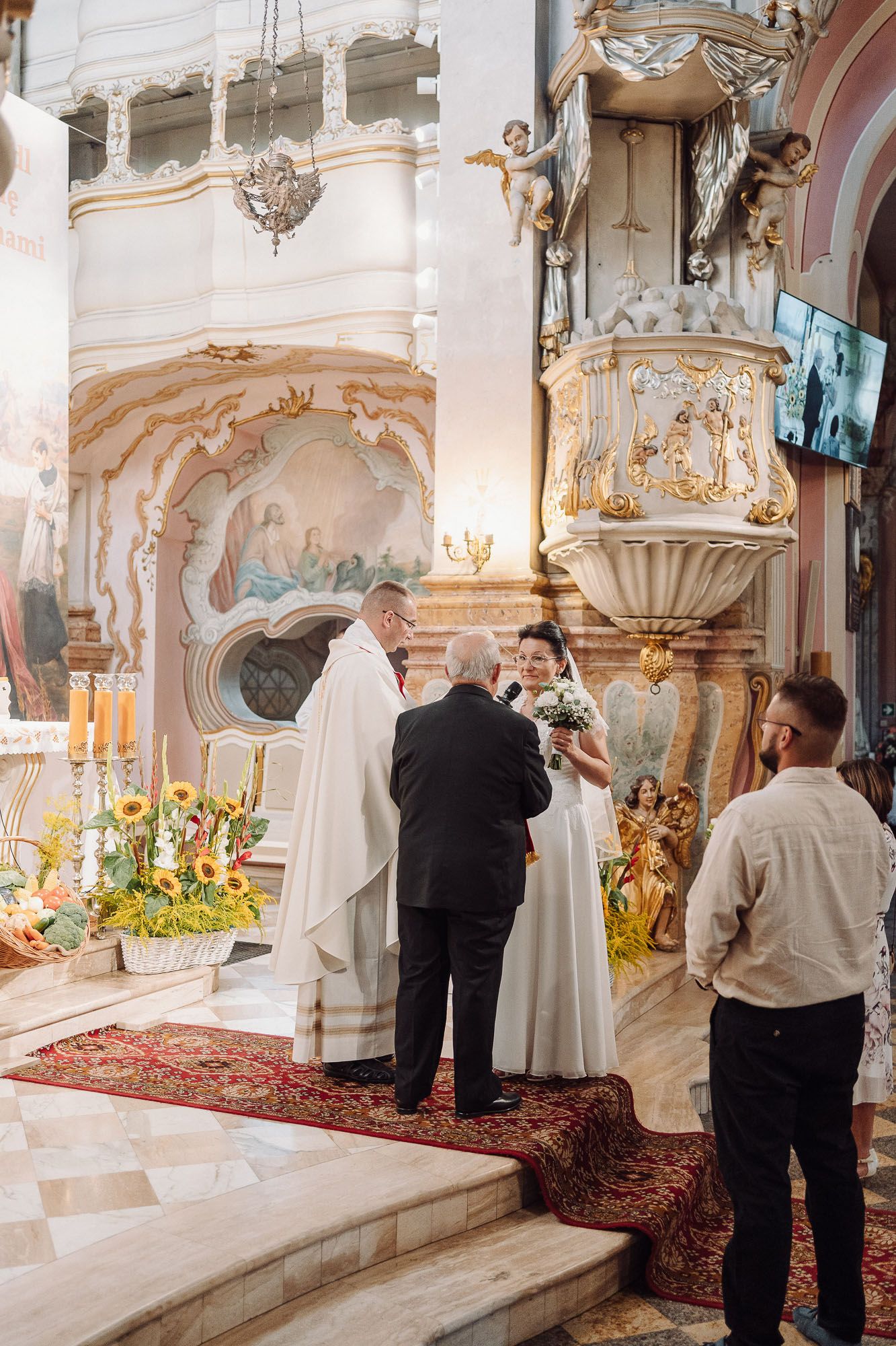 Ewa i Stefan podczas ceremonii ślubnej w kościele, uchwyceni w naturalnym reportażu ślubnym.