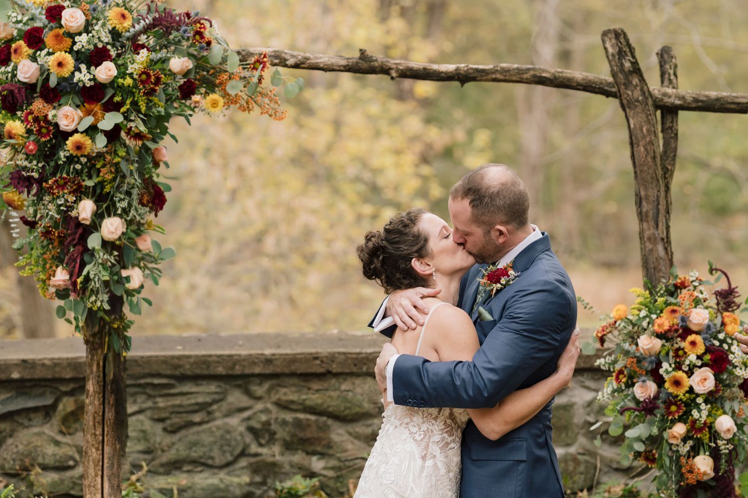 A husband and wife having their first kiss. The photo has been edited to remove the officiant from the background.