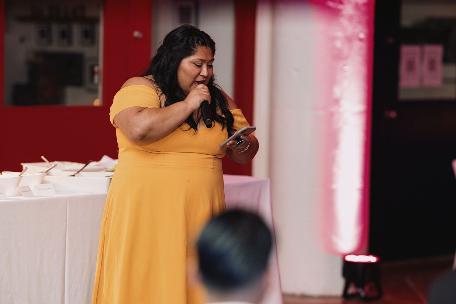 A friend reading a speech from their phone at a wedding