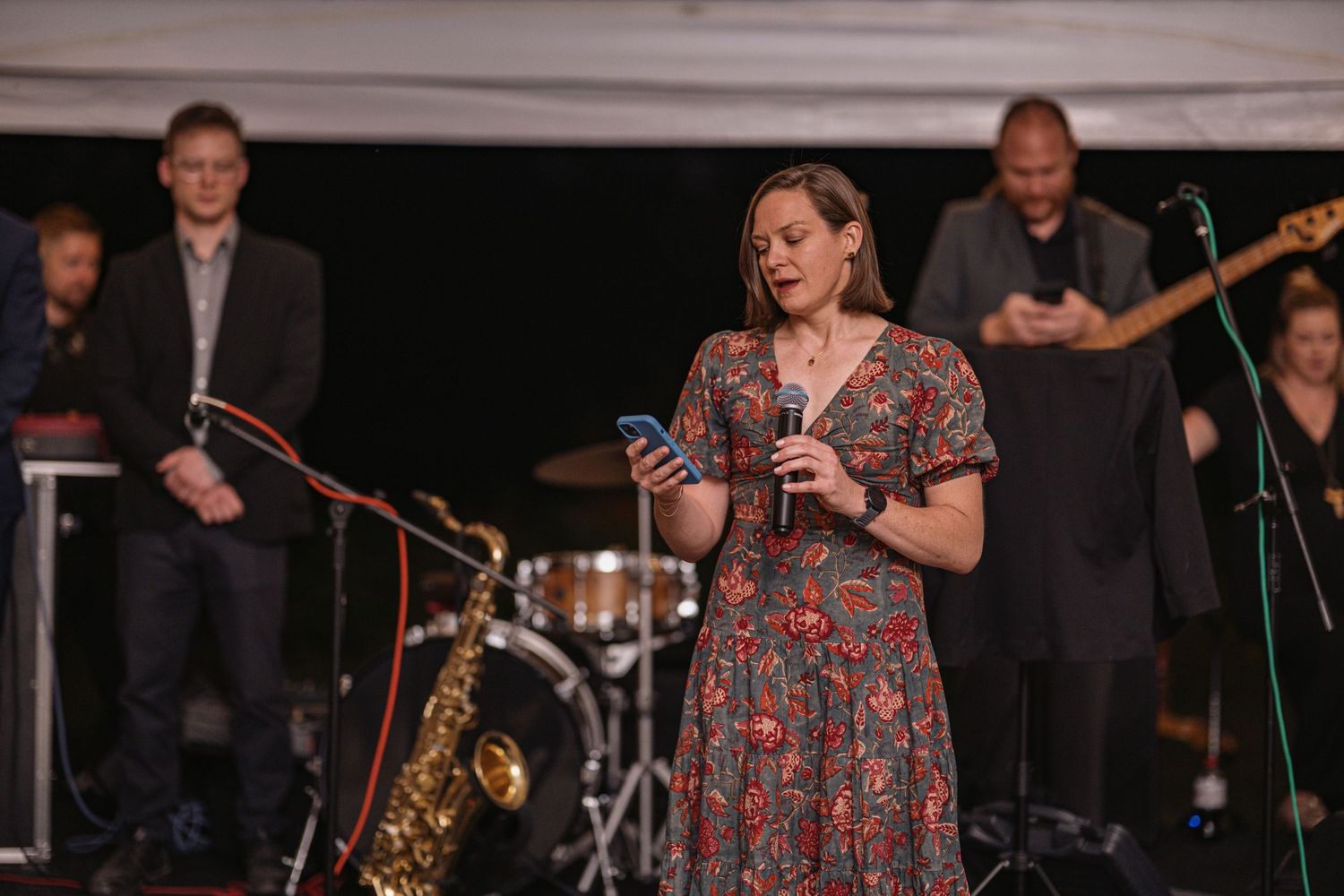 A friend reading a speech from their phone at a wedding