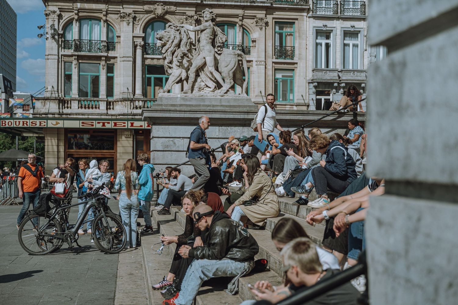 People sitting on the steps of a building in Brussels, Belgium