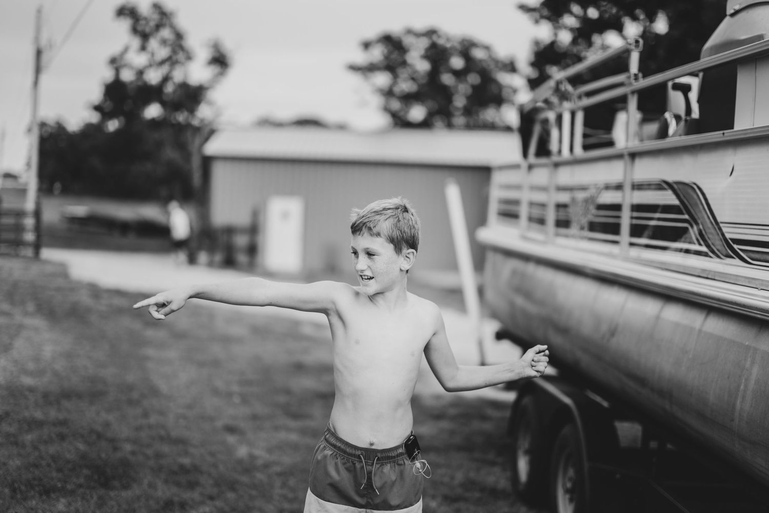 Vintage black and white photo of a person posing playfully by a classic car — nostalgic Tulsa family photo byDaviel.com