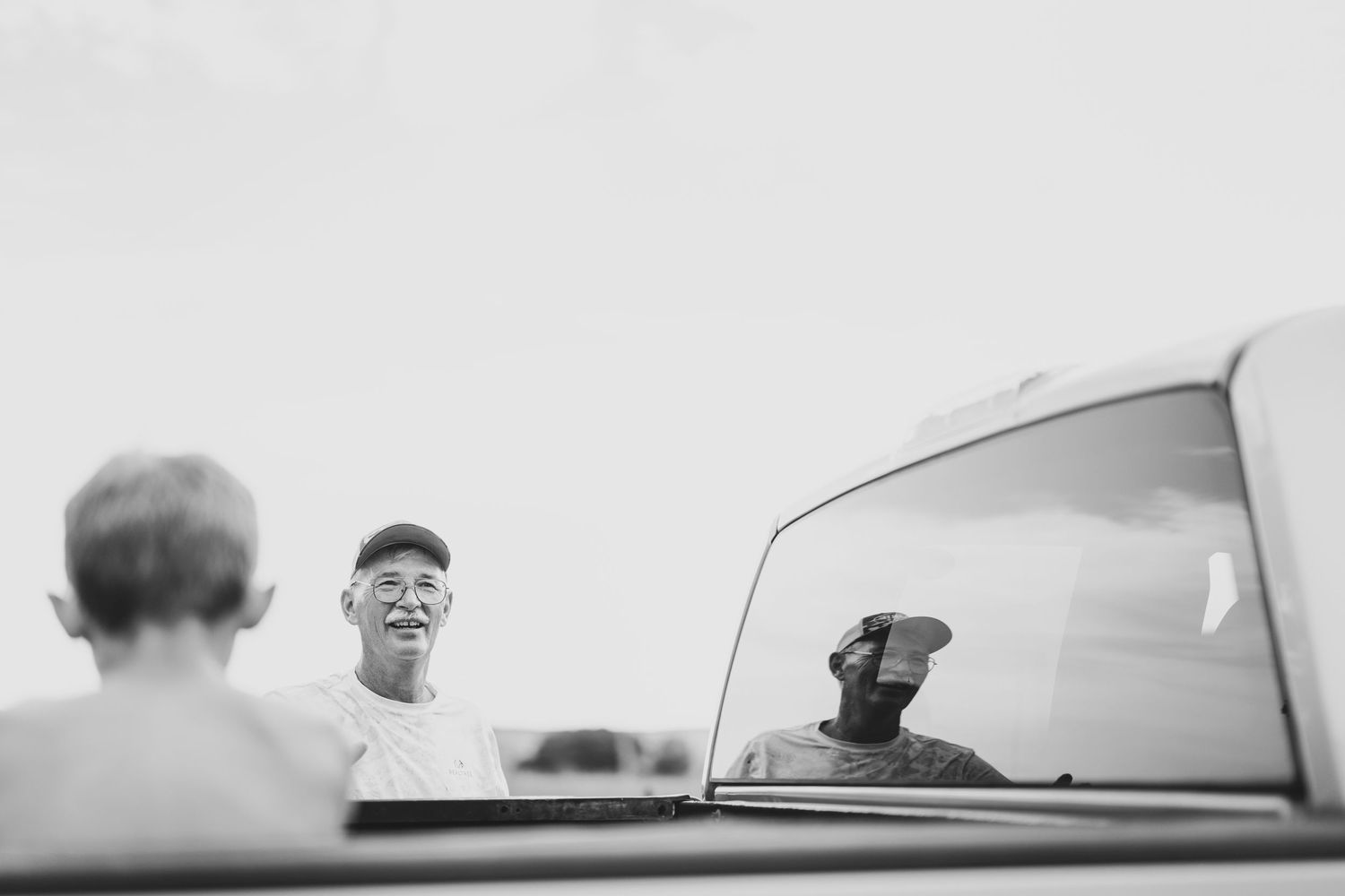 Vintage photo of person sitting in a car through windshield view — nostalgic Tulsa family photo byDaviel.com