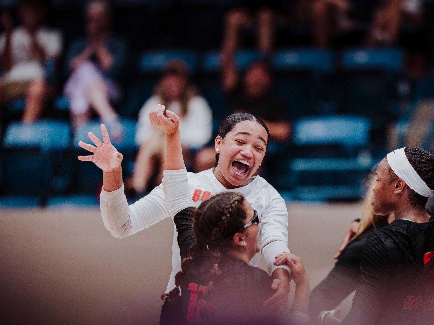 A series of volleyball players celebrating on the court during a match with excited expressions and raised arms. photo bydaviel.com
