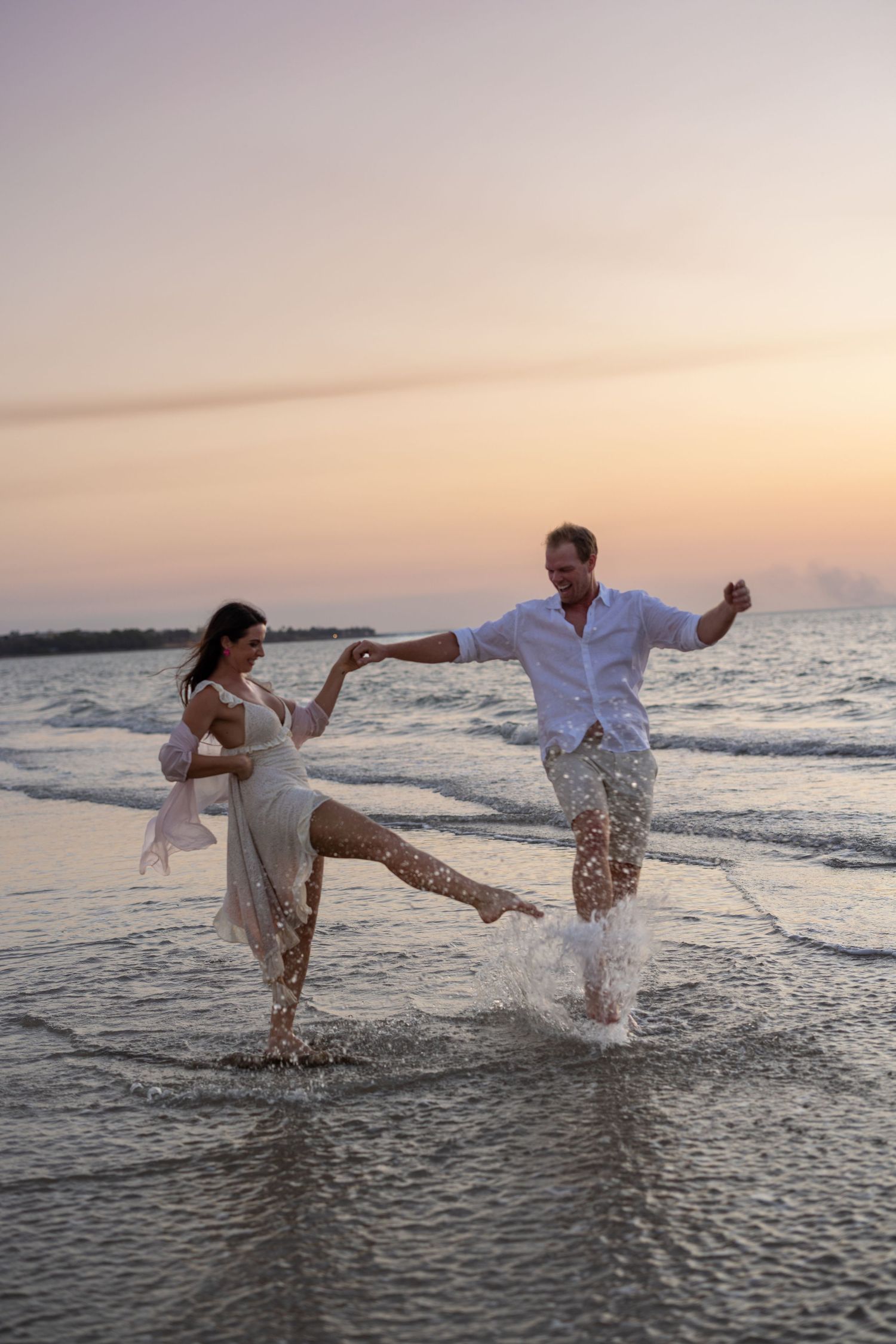 Outdoor couples photography session at sunset in Darwin featuring playful beach portraits captured by Julie Françoise Imagery