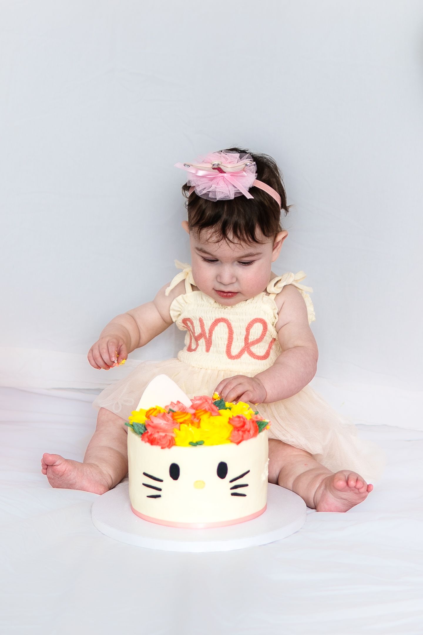 Close-up of birthday celebration with Hello Kitty cake topped with bright yellow and pink flowers.