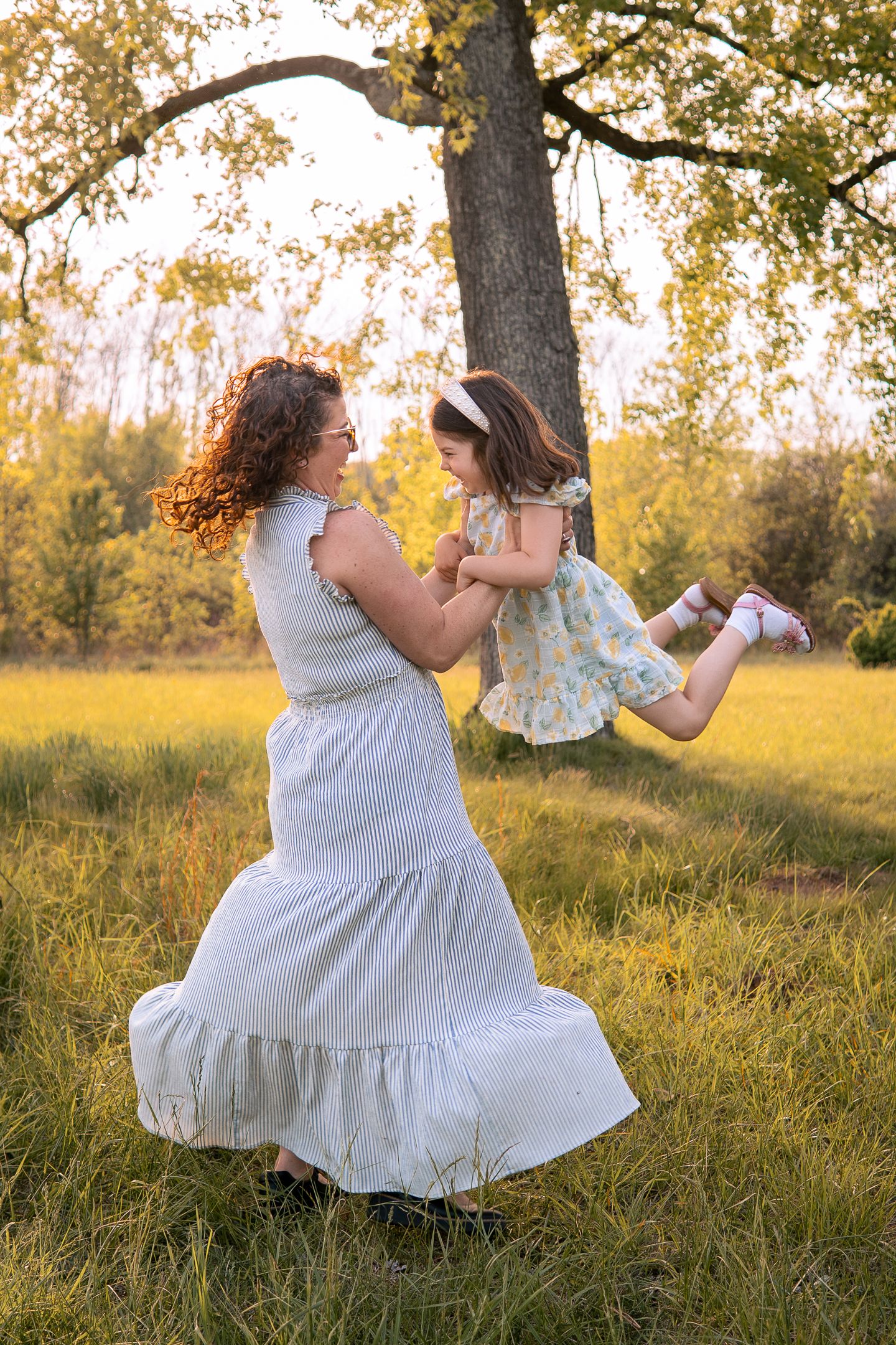 A joyful moment captured in a sunlit meadow with a white dress twirling and golden fall foliage in the background.