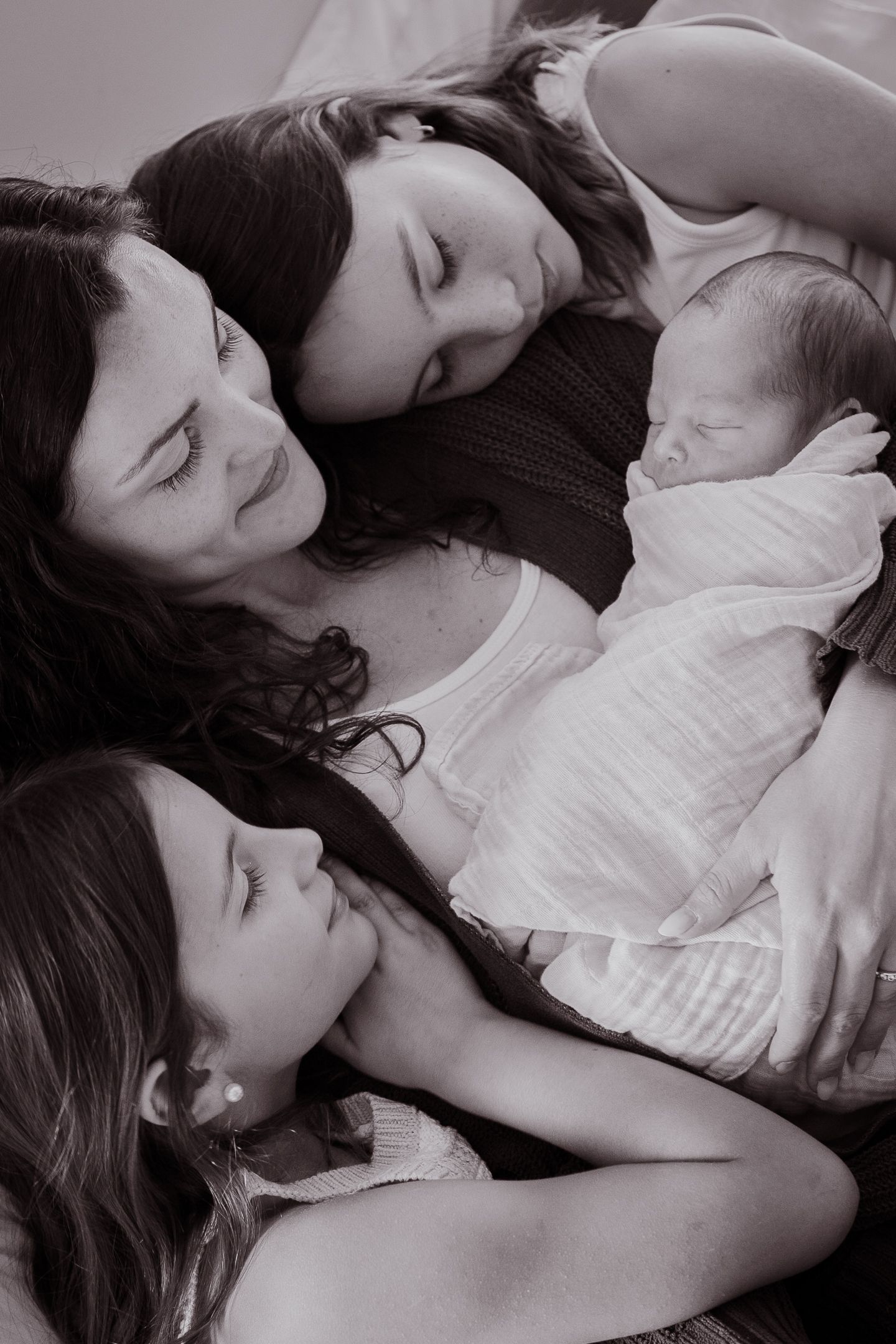 Black and white portraits capturing intimate family moments with a newborn.