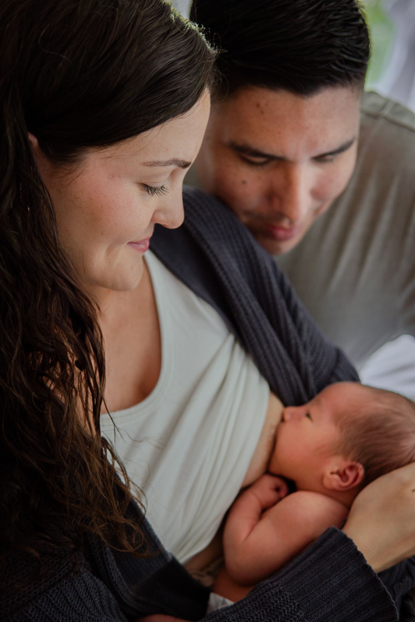 A parent tenderly cradles and nurtures their newborn baby in an intimate moment.