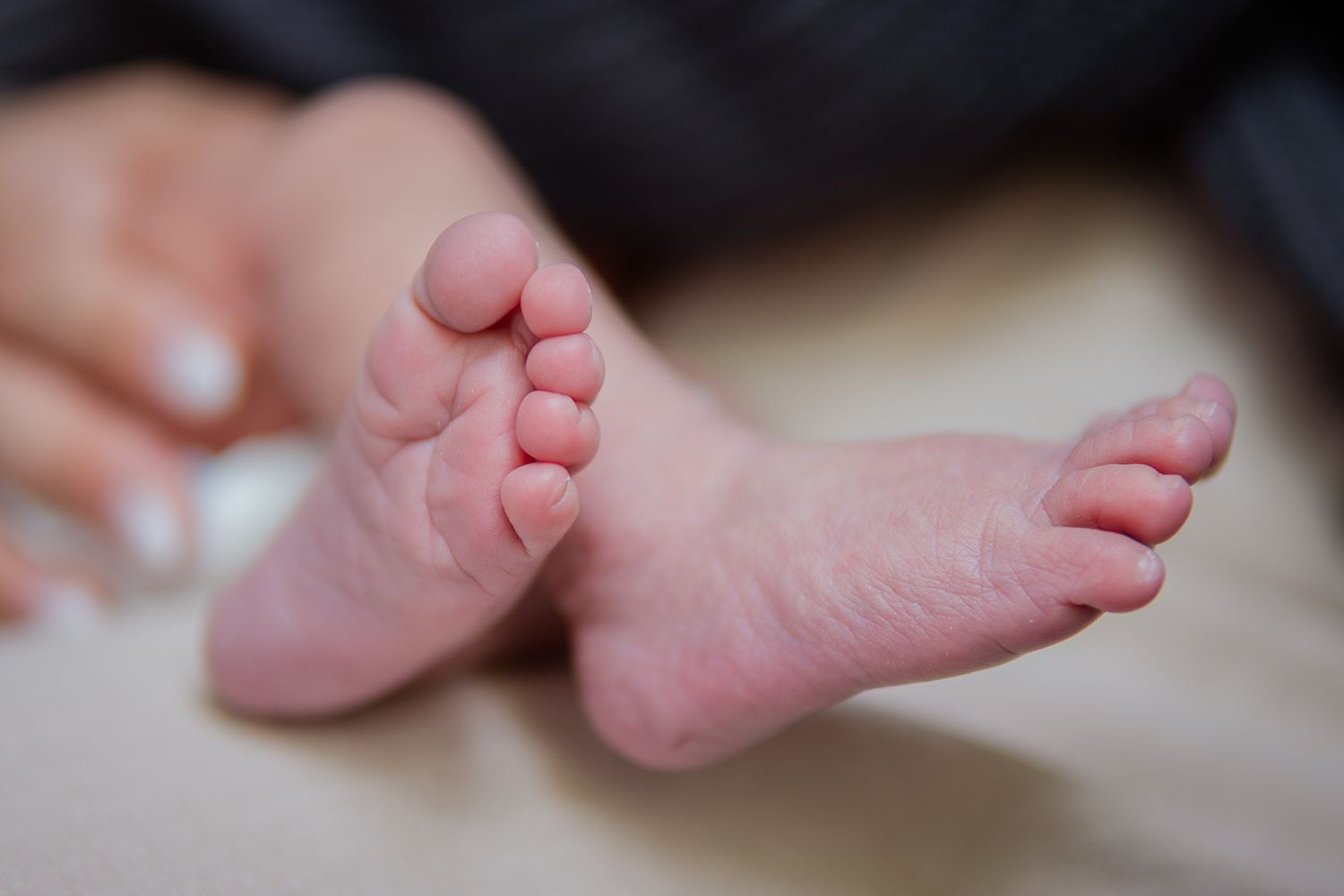 Series of close-up shots showing tiny newborn feet against a light background.