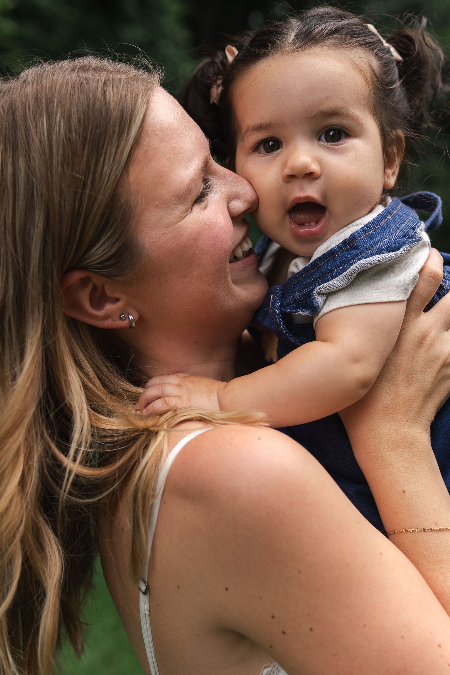 A series of connected images showing tender moments between a mother and child sharing kisses and laughter.