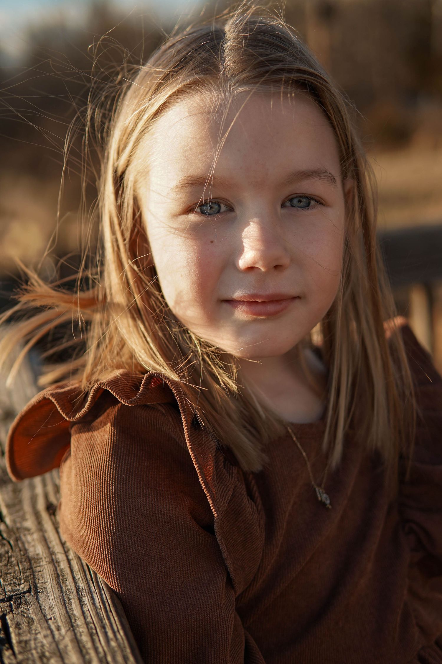A series of candid portrait shots showing someone wearing a brown sweater in warm natural lighting with a subtle smile.