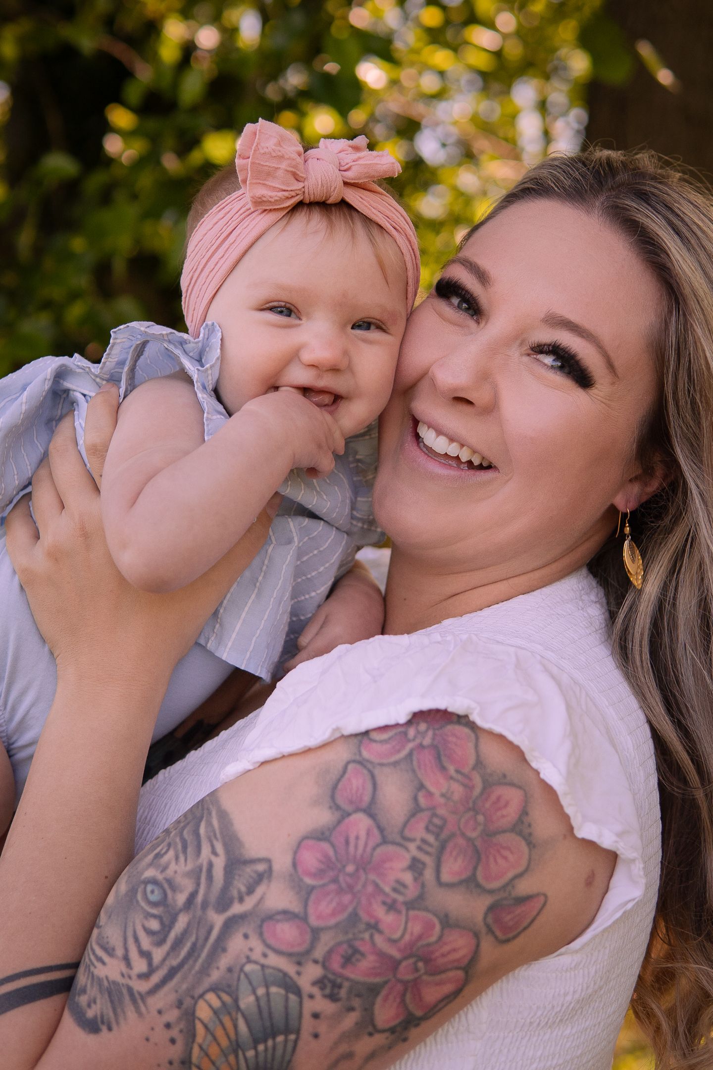 Candid outdoor portrait showing happy expressions and laughter between two people in matching pink outfits.