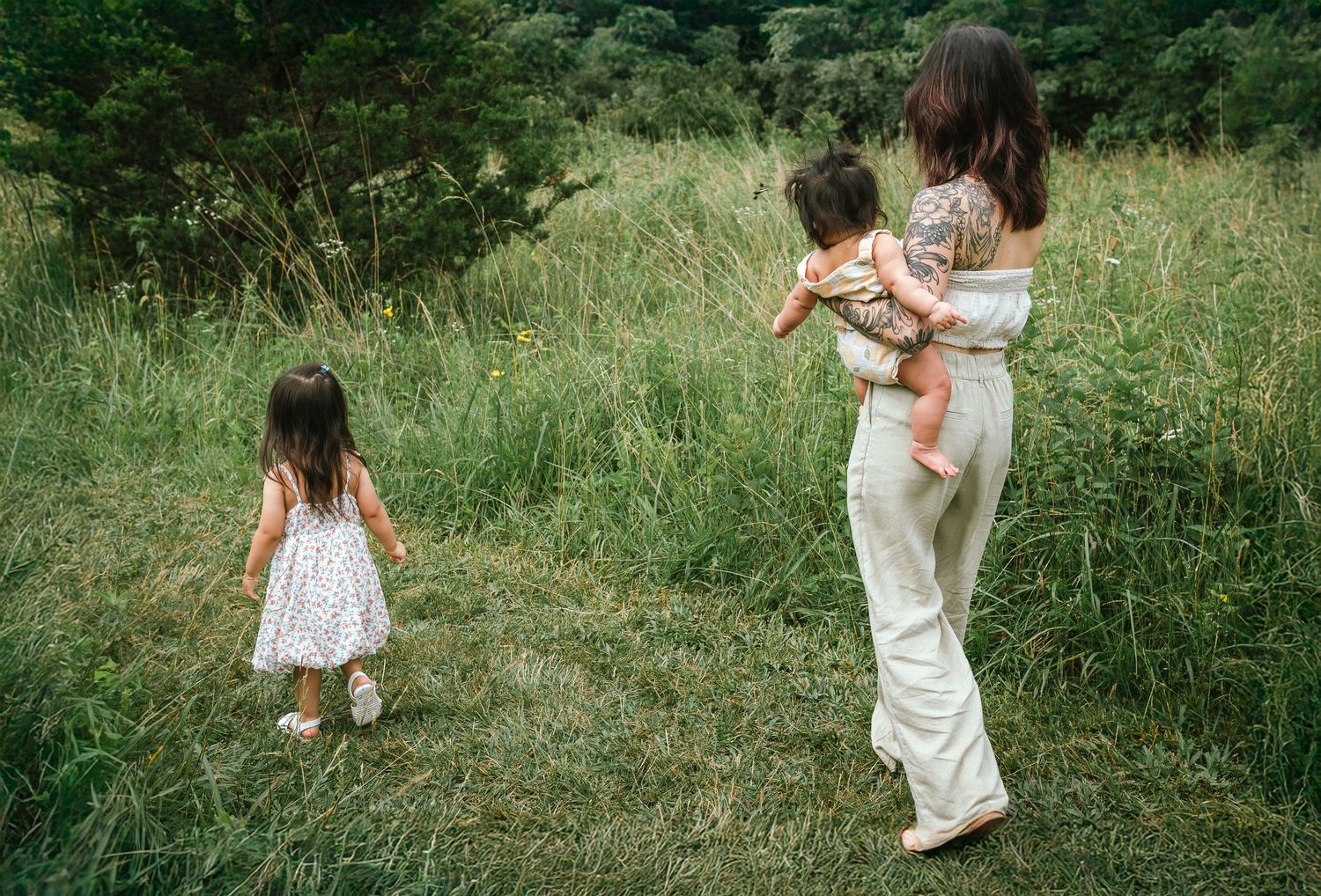 A family enjoying time together in a wildflower meadow on a sunny afternoon.