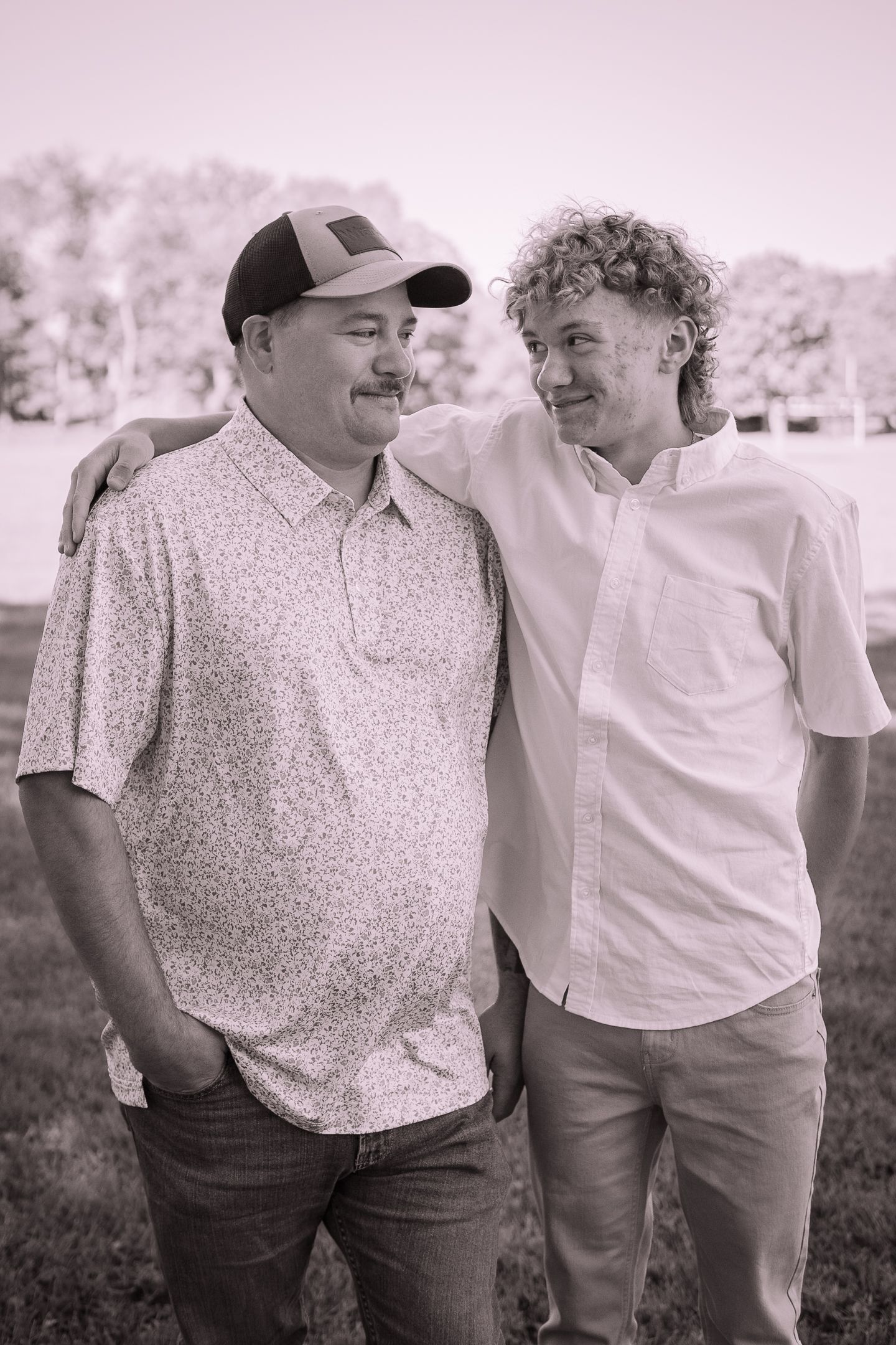 Black and white casual portrait of two people outdoors sharing a warm moment.
