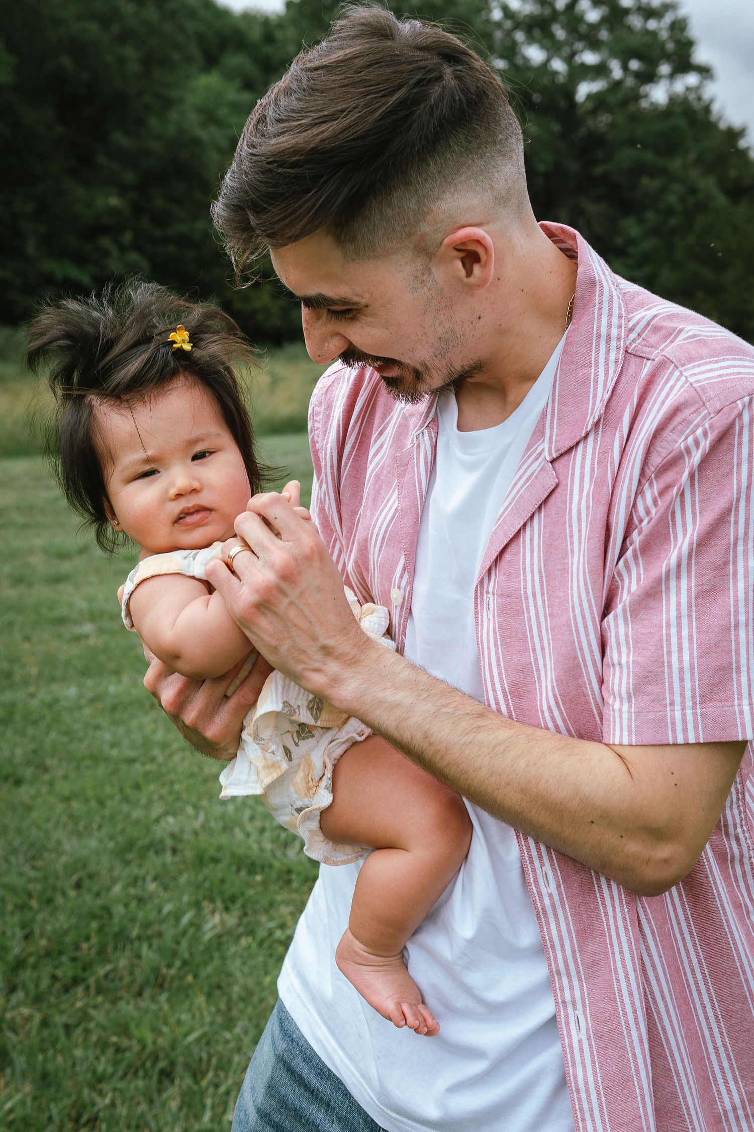 Close-up sequence showing playful interaction in pink striped shirt outdoors.