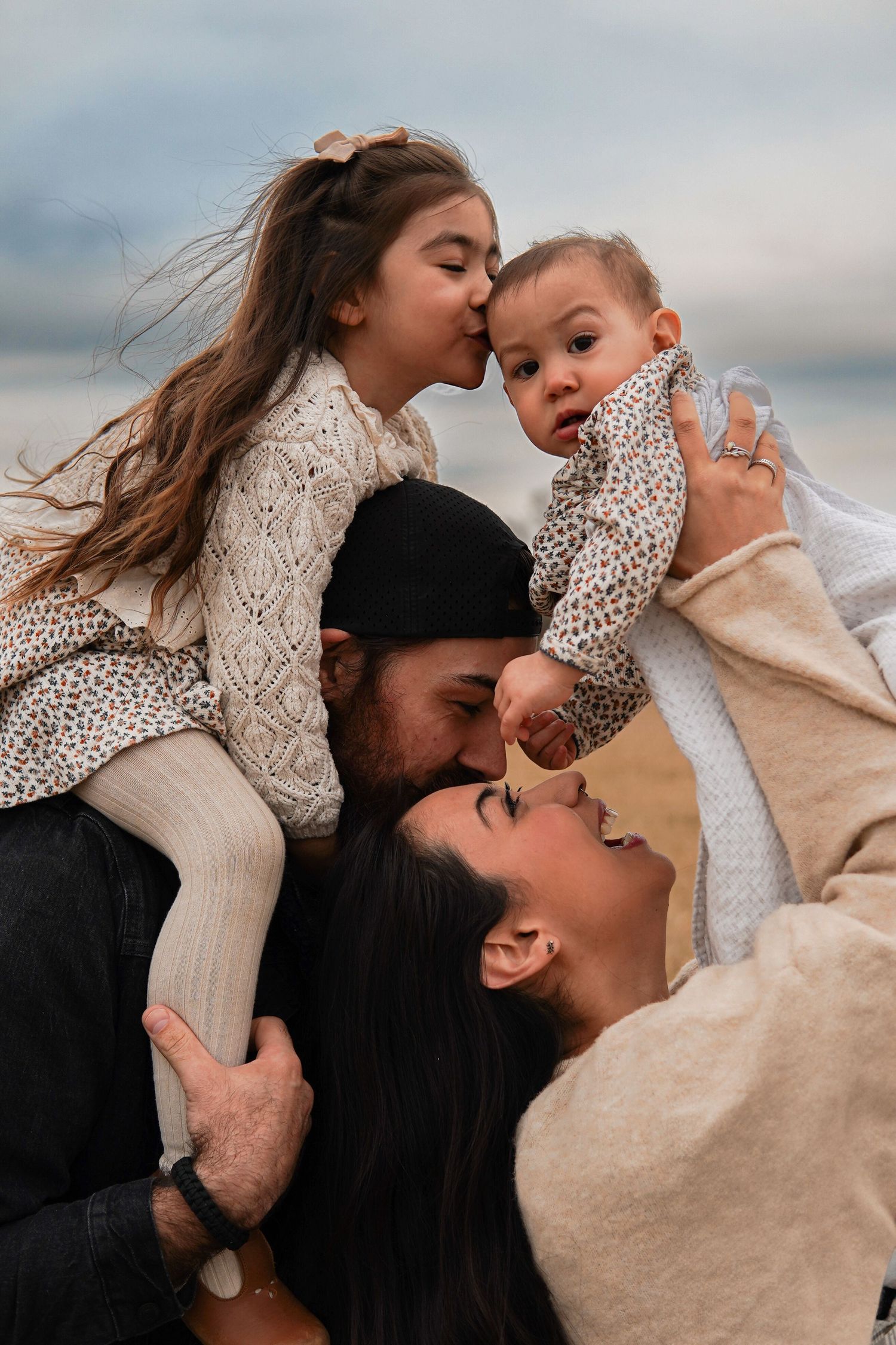 A series of joyful moments between parent and child sharing playful kisses together outdoors at sunset.