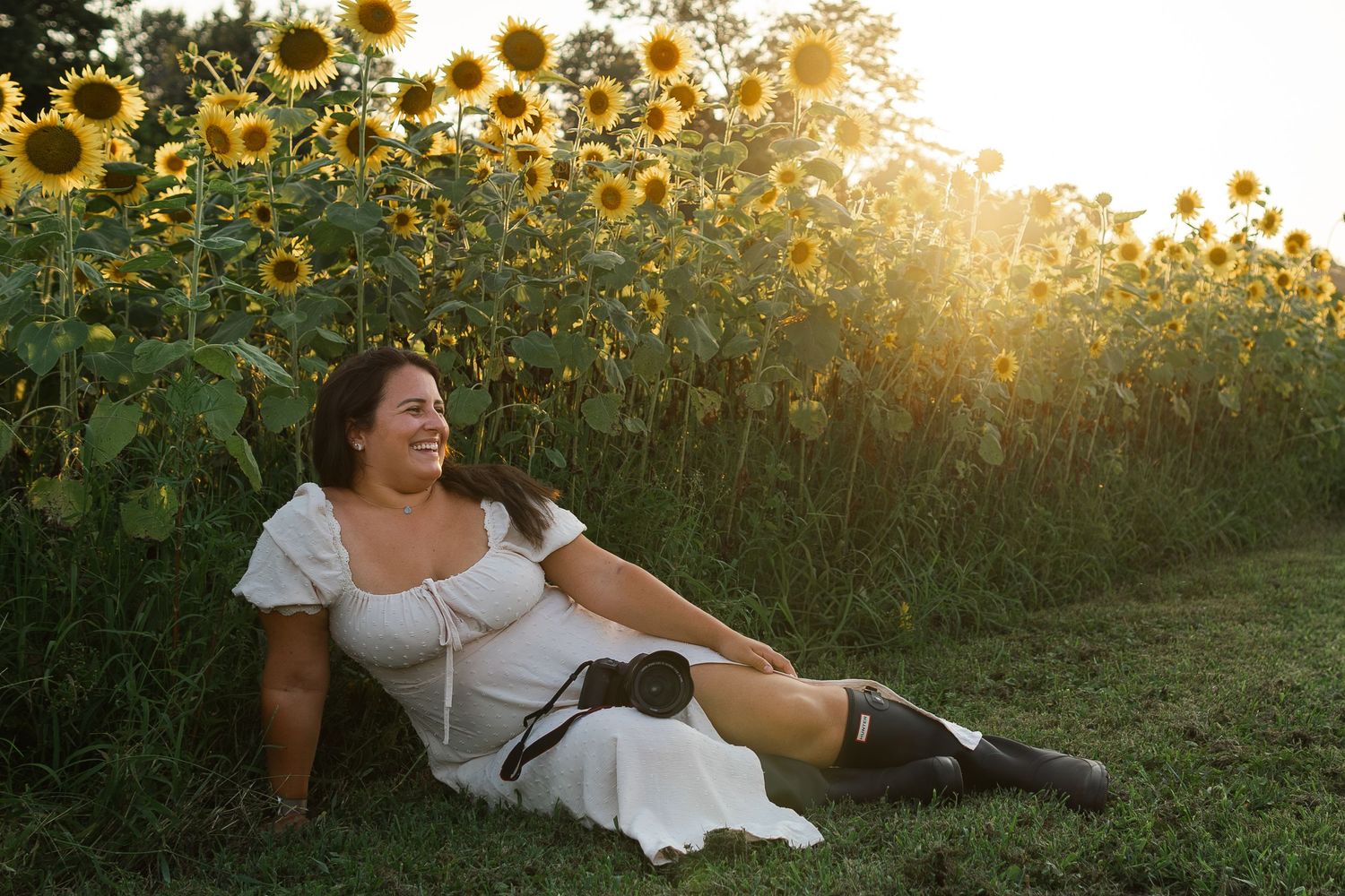 A joyful moment captured in a sunflower field at golden hour with warm sunlight filtering through tall blooming flowers.
