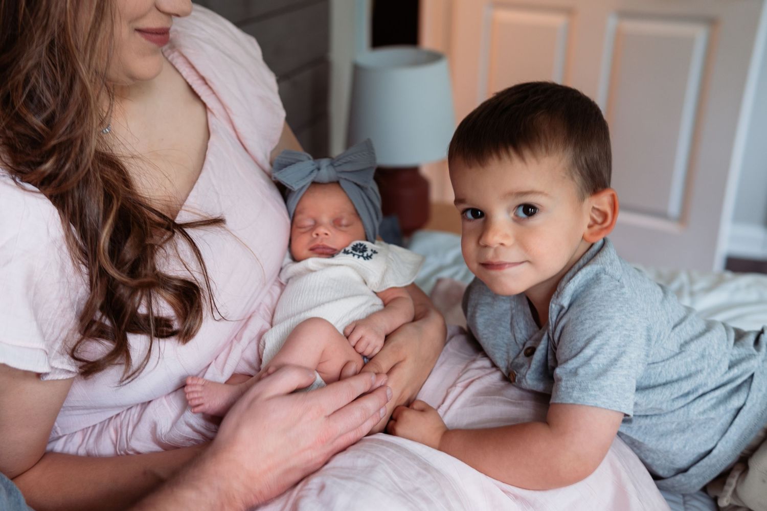 Family portrait series showing parents and siblings bonding with their new baby.