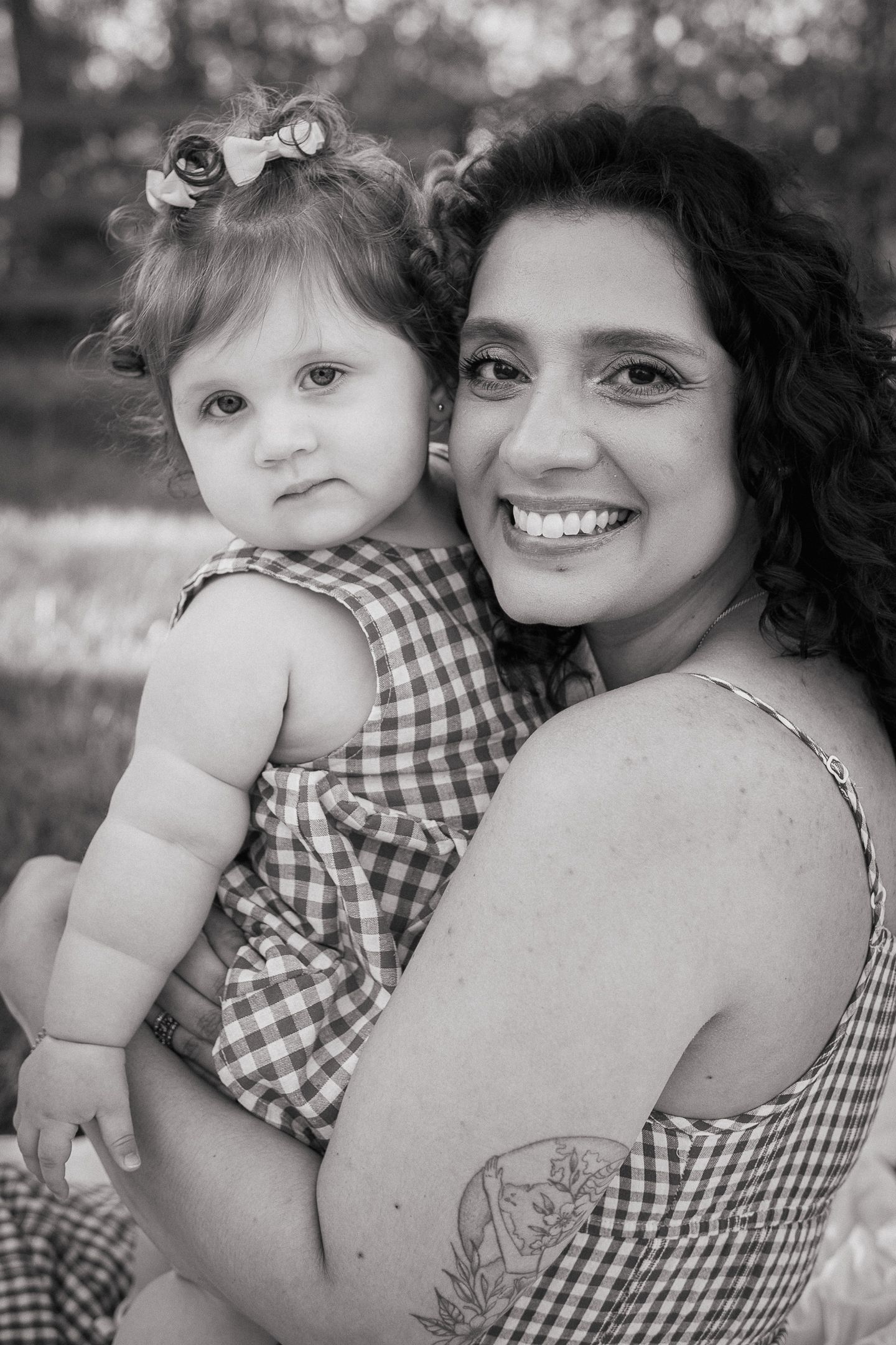 Mother smiling and holding her child during a spring family photo session in Northern Virginia, captured by a local motherhood photographer.