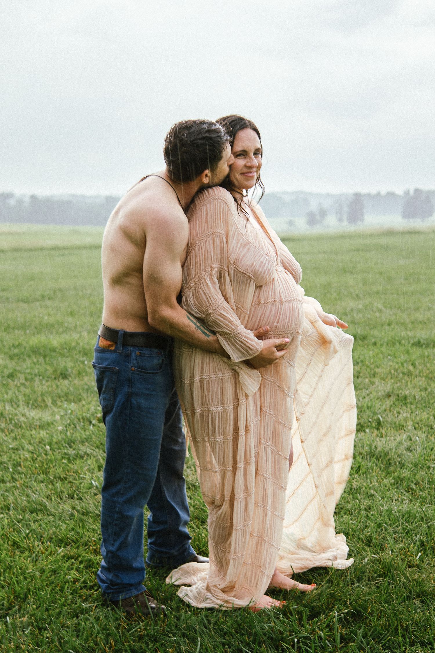 Maternity photo sequence in a misty field shows couple embracing in ethereal peach-colored dress on green grass.