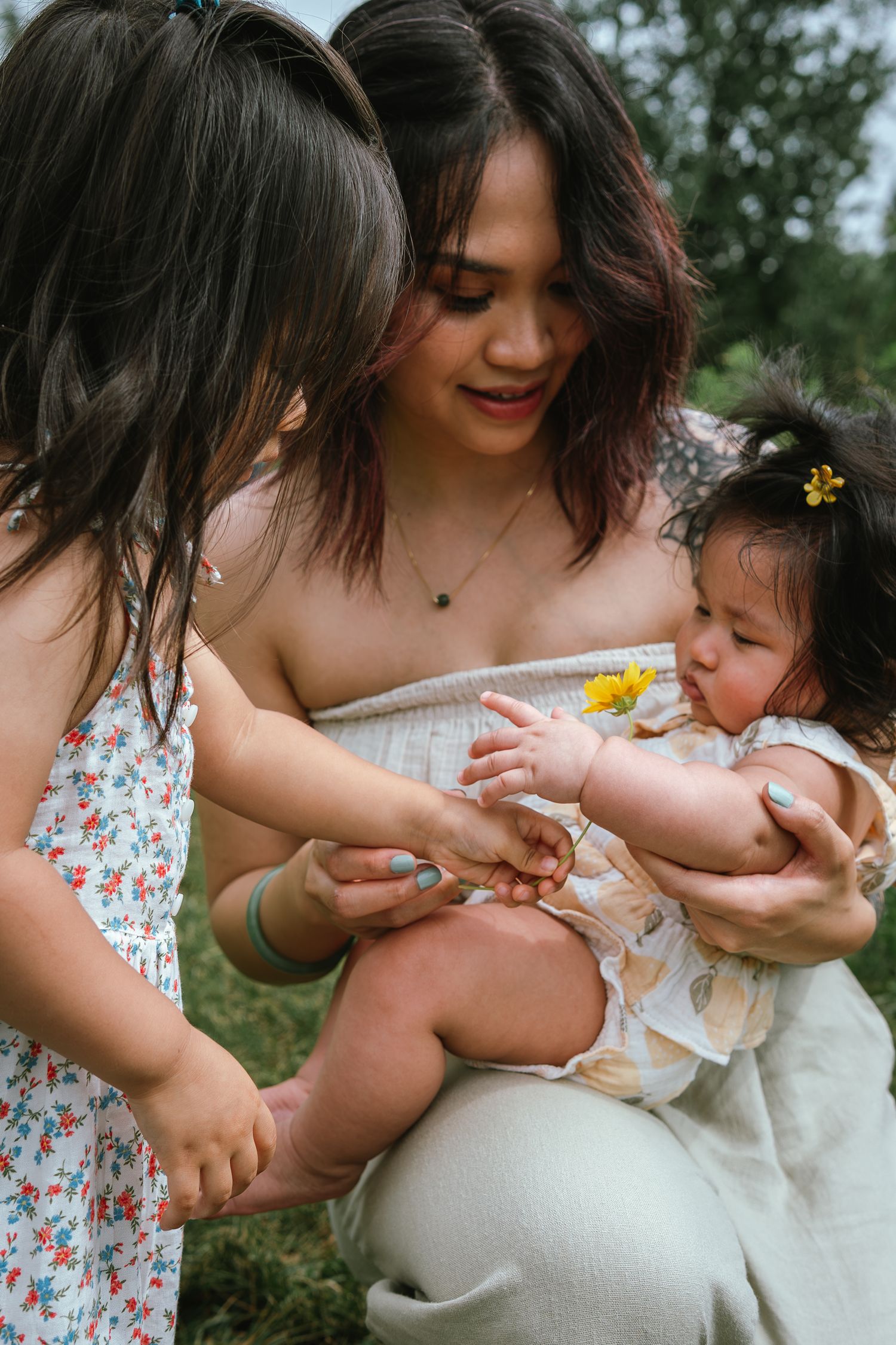 An intimate family moment captured outdoors with gentle interactions and natural expressions.