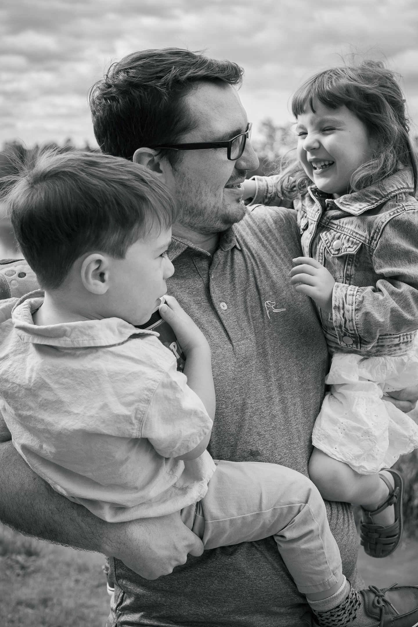 Black and white photo series showing tender candid family moments between a parent and toddler playing together.