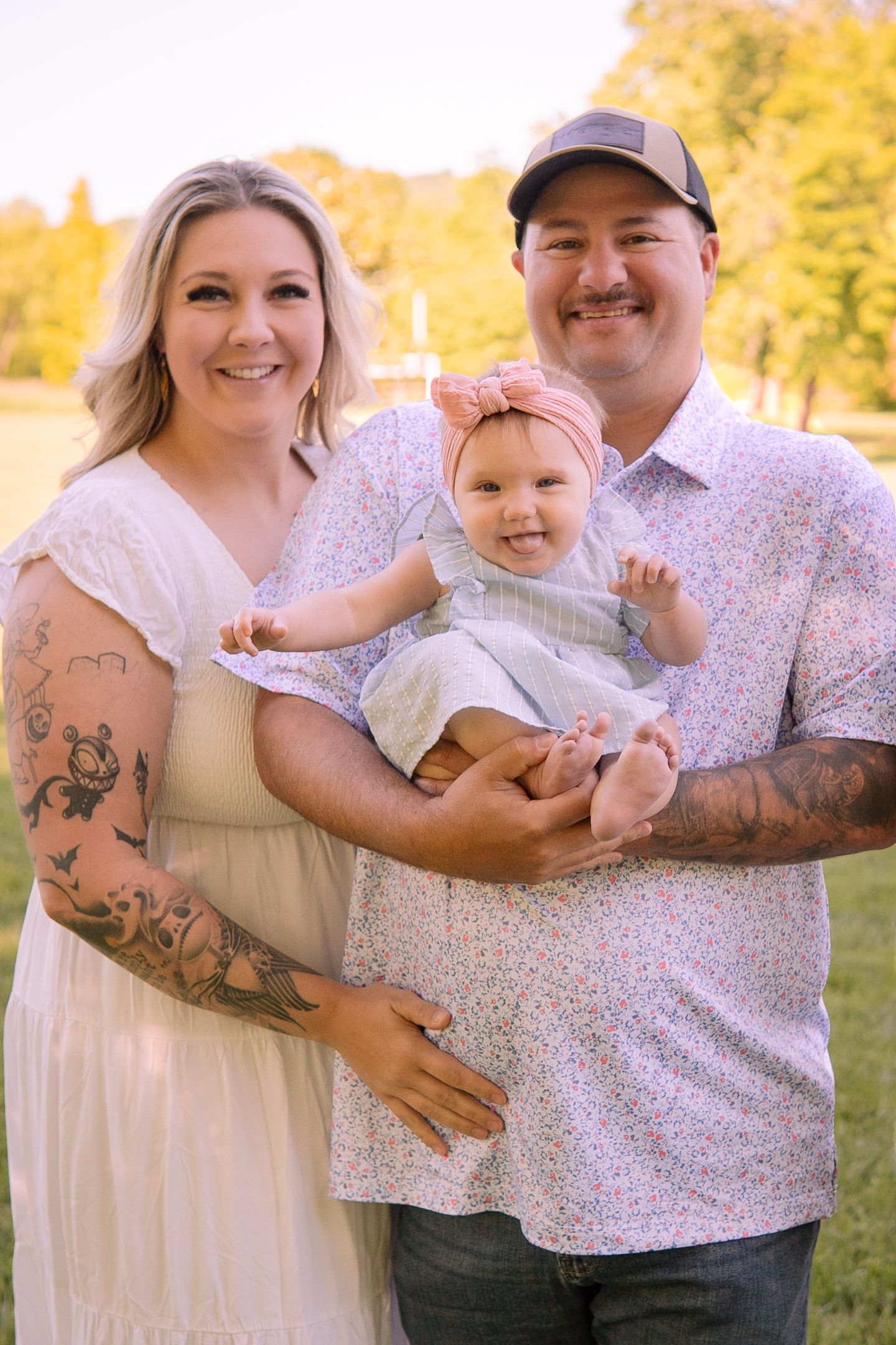 Family portrait in a sunny autumn park with floral outfits and matching white attire.
