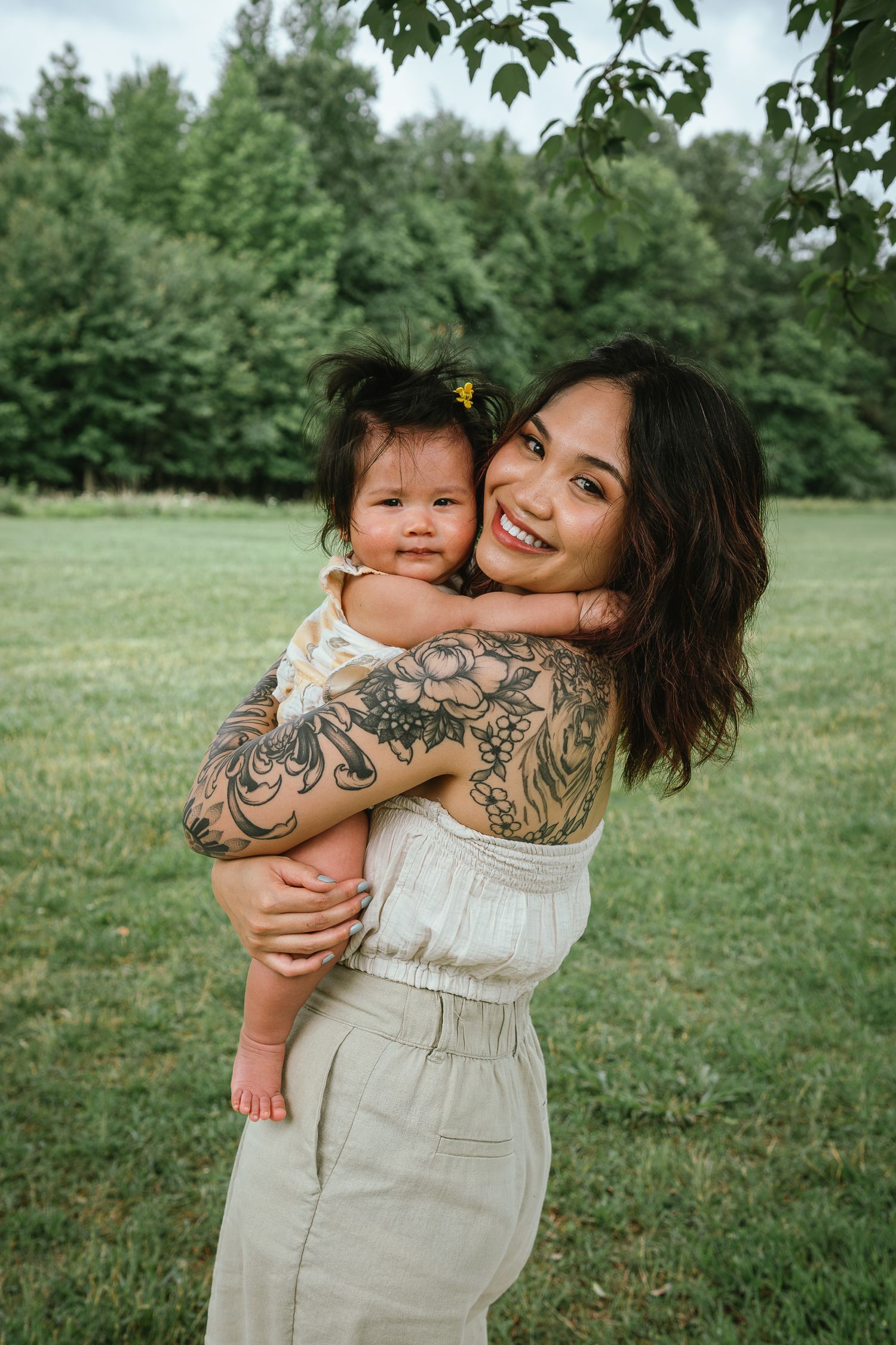 Outdoor portrait session featuring intimate family moments and artistic tattoo details.