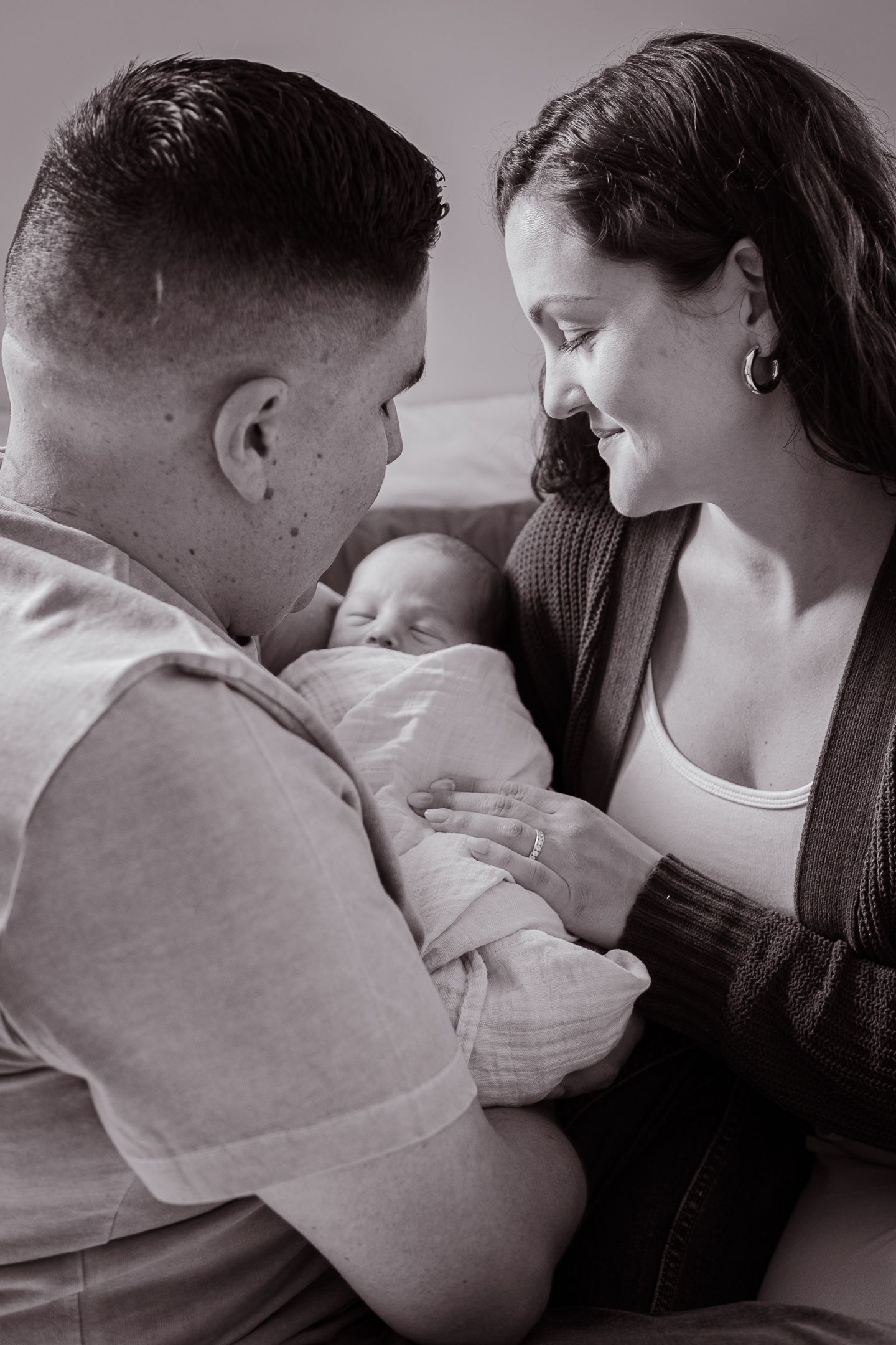 A sequence of black and white photos showing tender bonding moments with a baby.