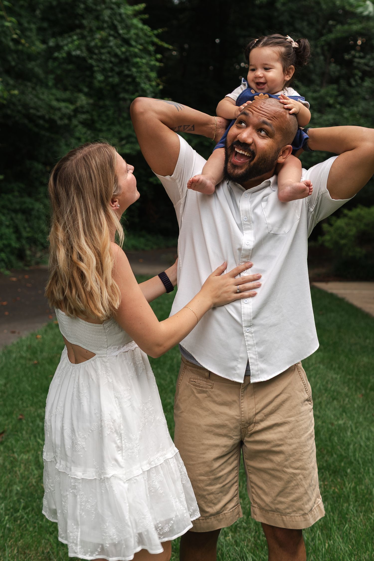 A playful sequence of a couple dancing and laughing together in a grassy outdoor setting.