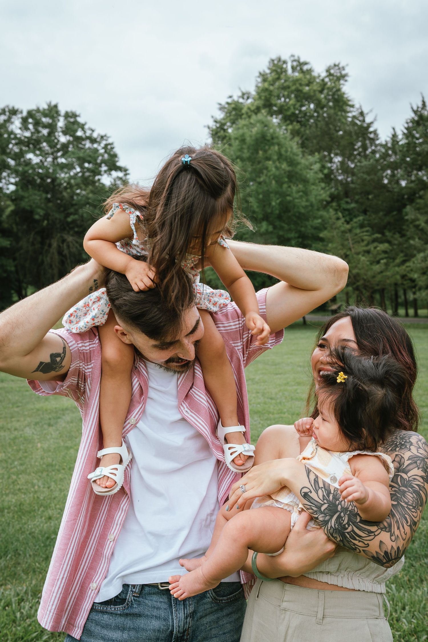 Sweet candid moments of family play in a grassy outdoor setting.