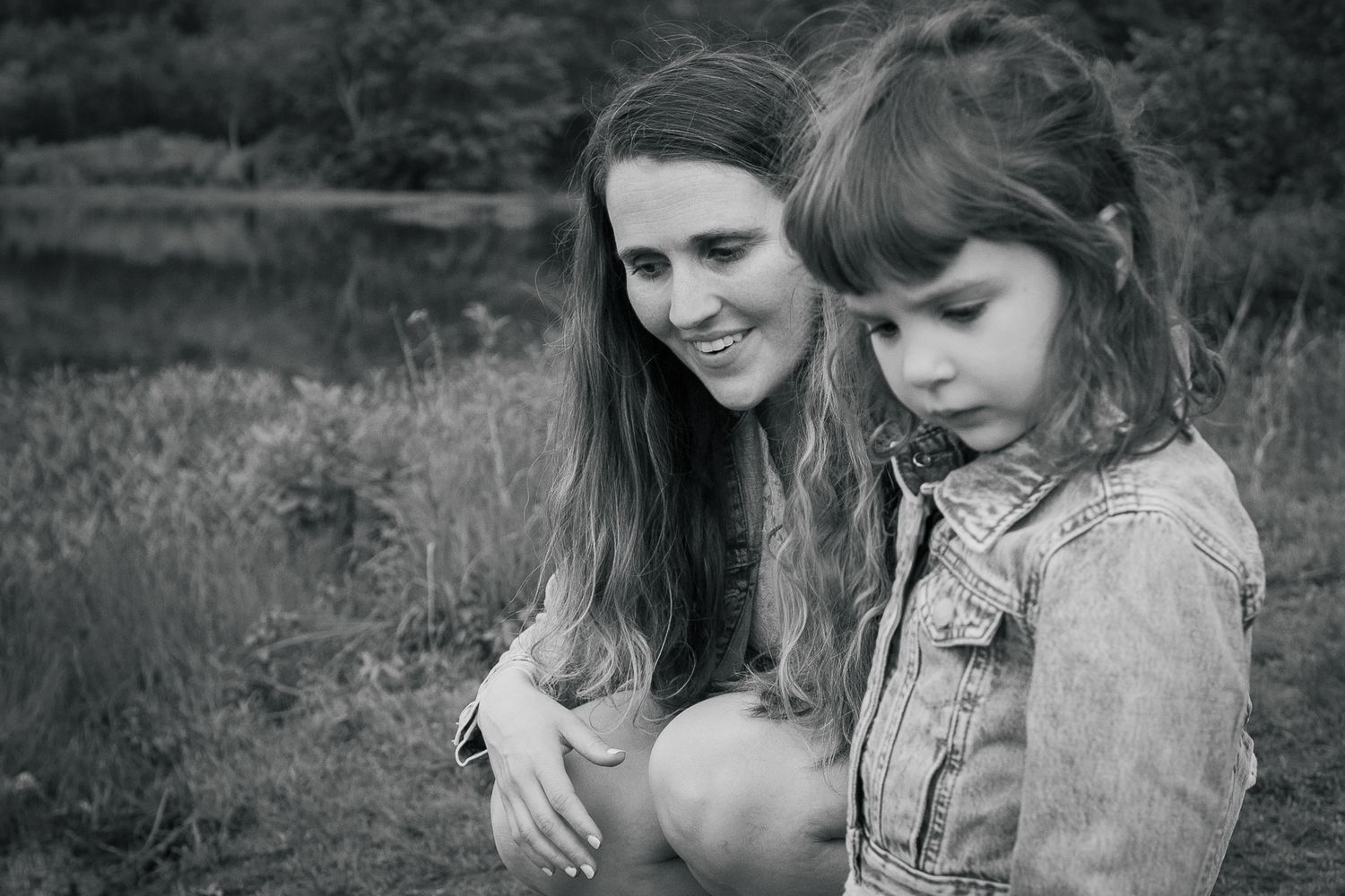 A series of intimate black and white photographs showing tender moments between family members outdoors in nature.