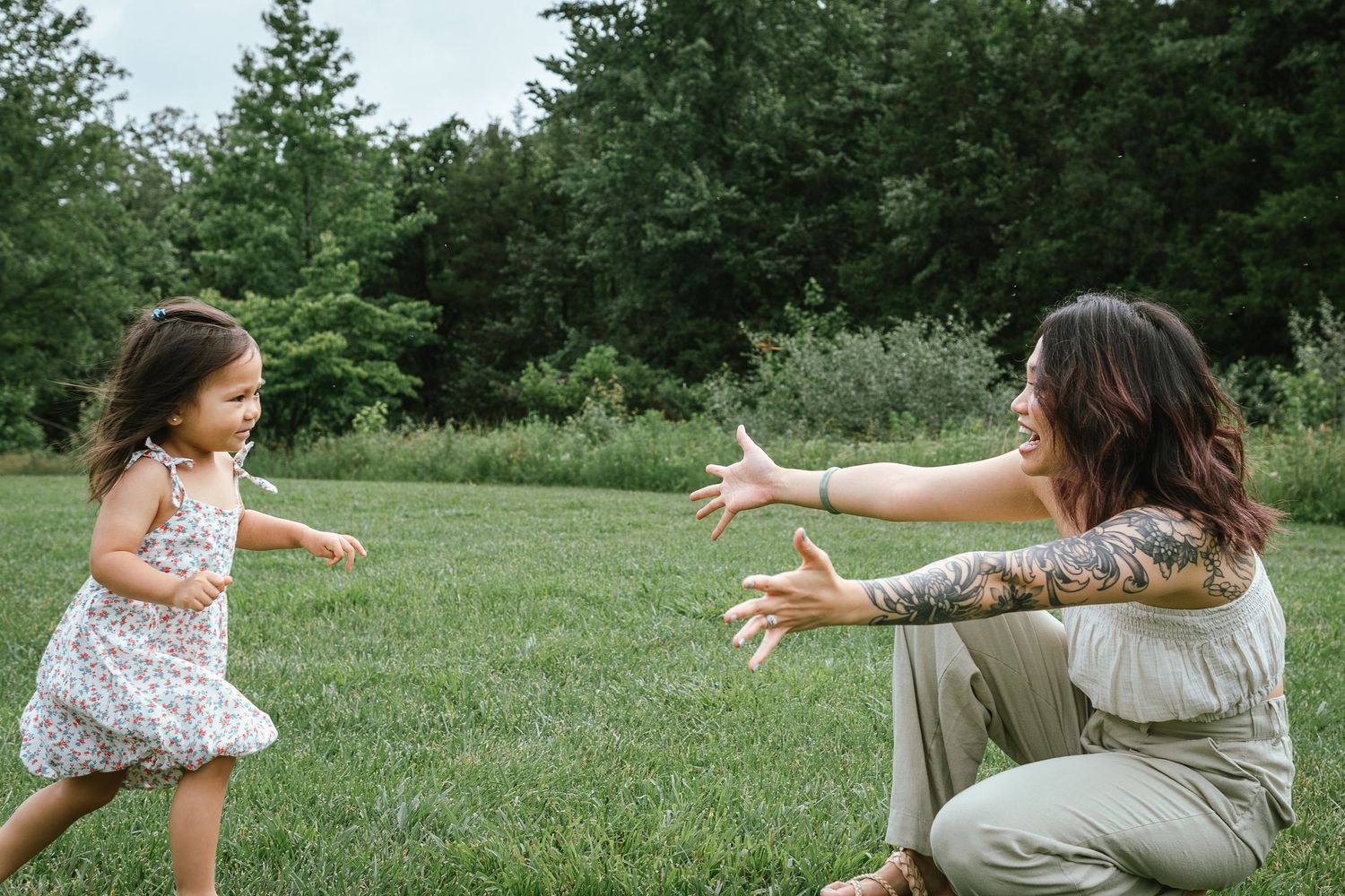 Playful family interaction captured on a grassy field with natural poses and movement.