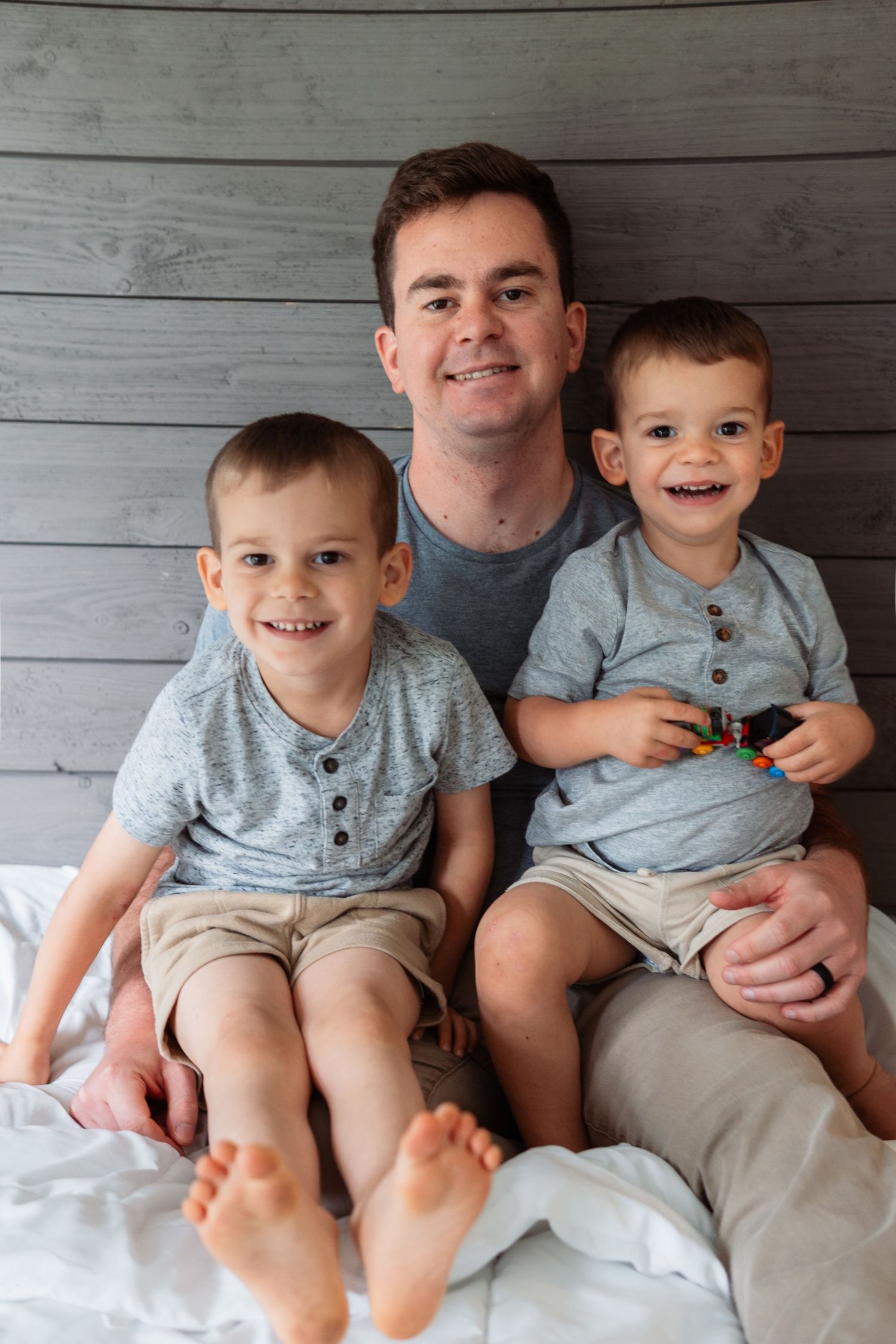 A series of progressive family photos showing growing closeness and laughter against a rustic gray wood wall background.