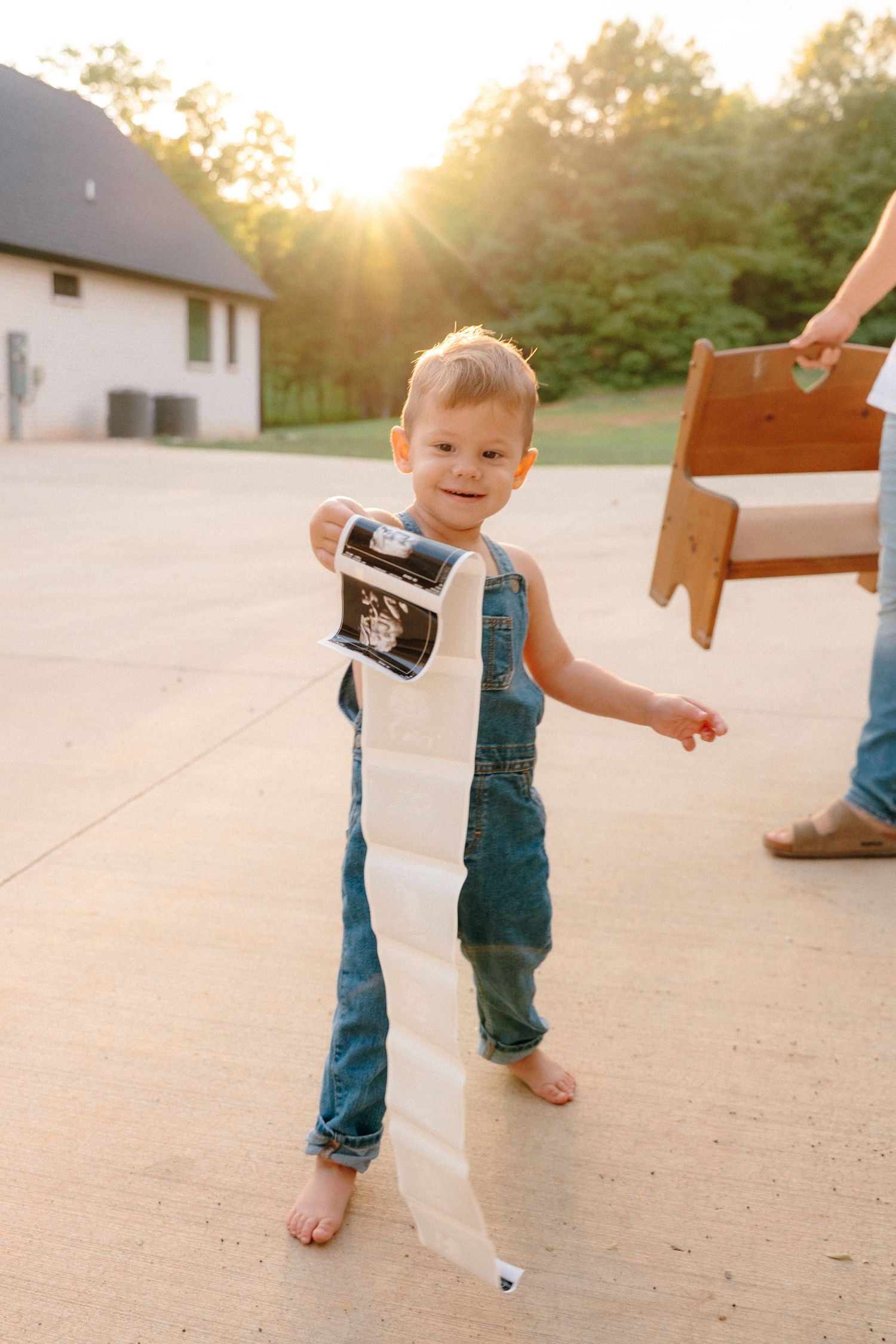 A series showing small feet and ultrasound photos on concrete during golden hour.