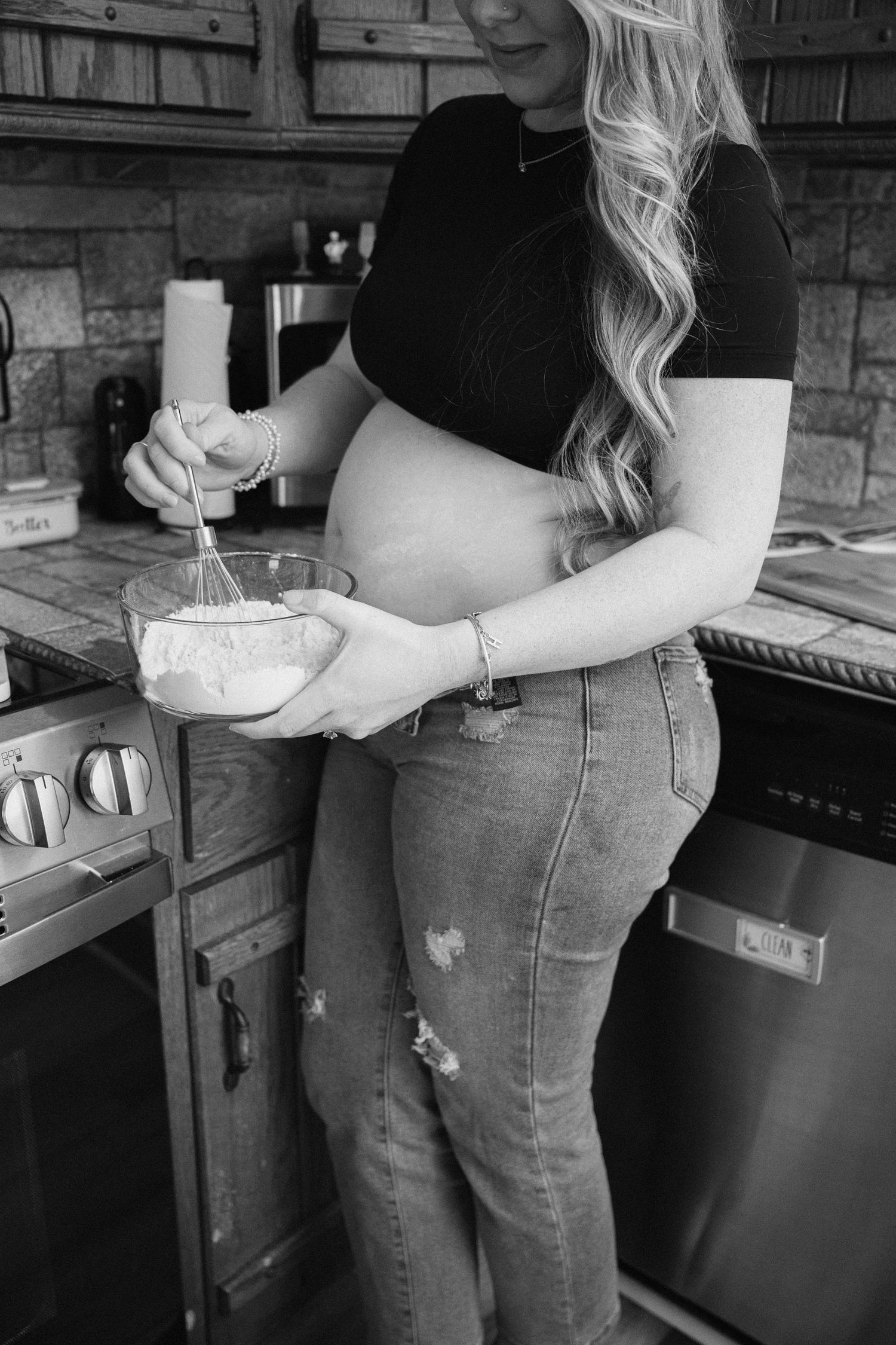 Close-up shots of a pregnant belly in blue jeans against a rustic wooden backdrop.