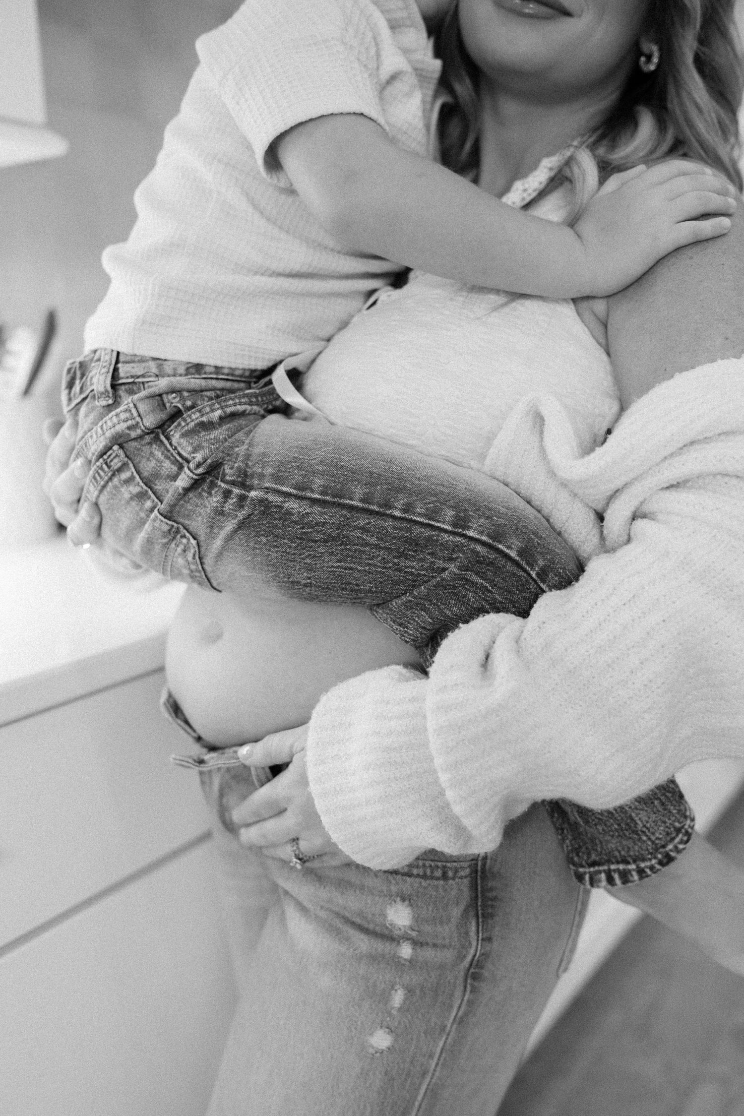Candid moments captured in black and white showing casual poses in jeans and sweater.