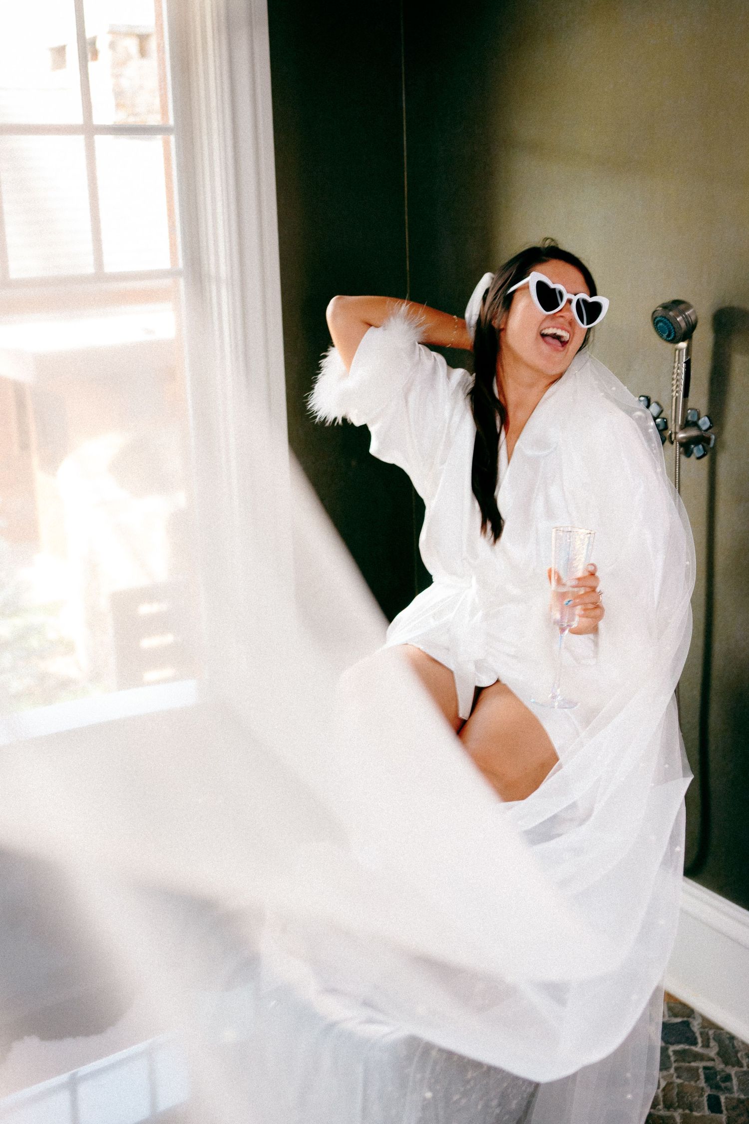 Artistic series of a bride in flowing white dress twirling against dark interior.