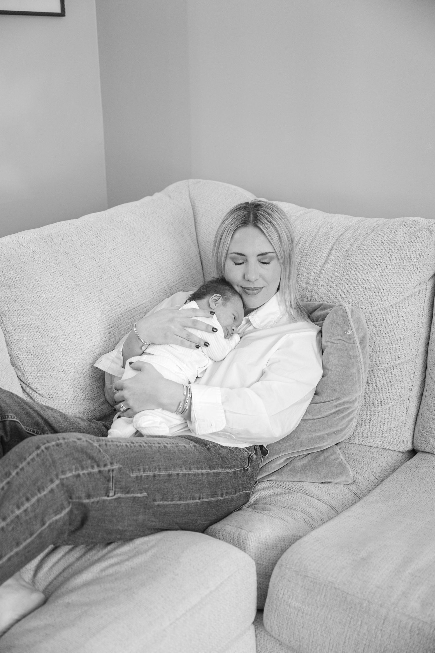 Relaxed lifestyle newborn photography session on grey couch.