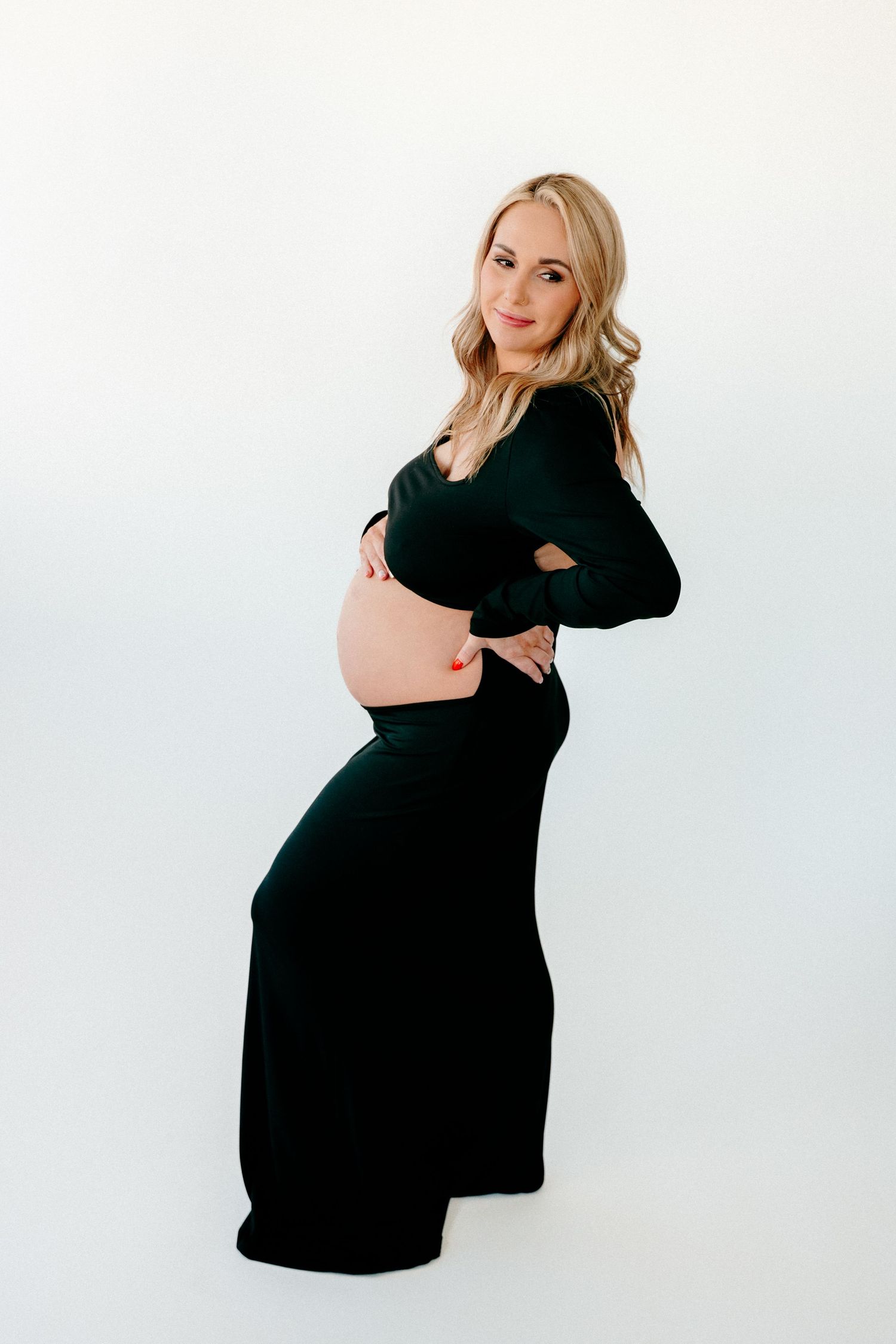 Artistic maternity photo sequence showing poses in a black dress against white background.