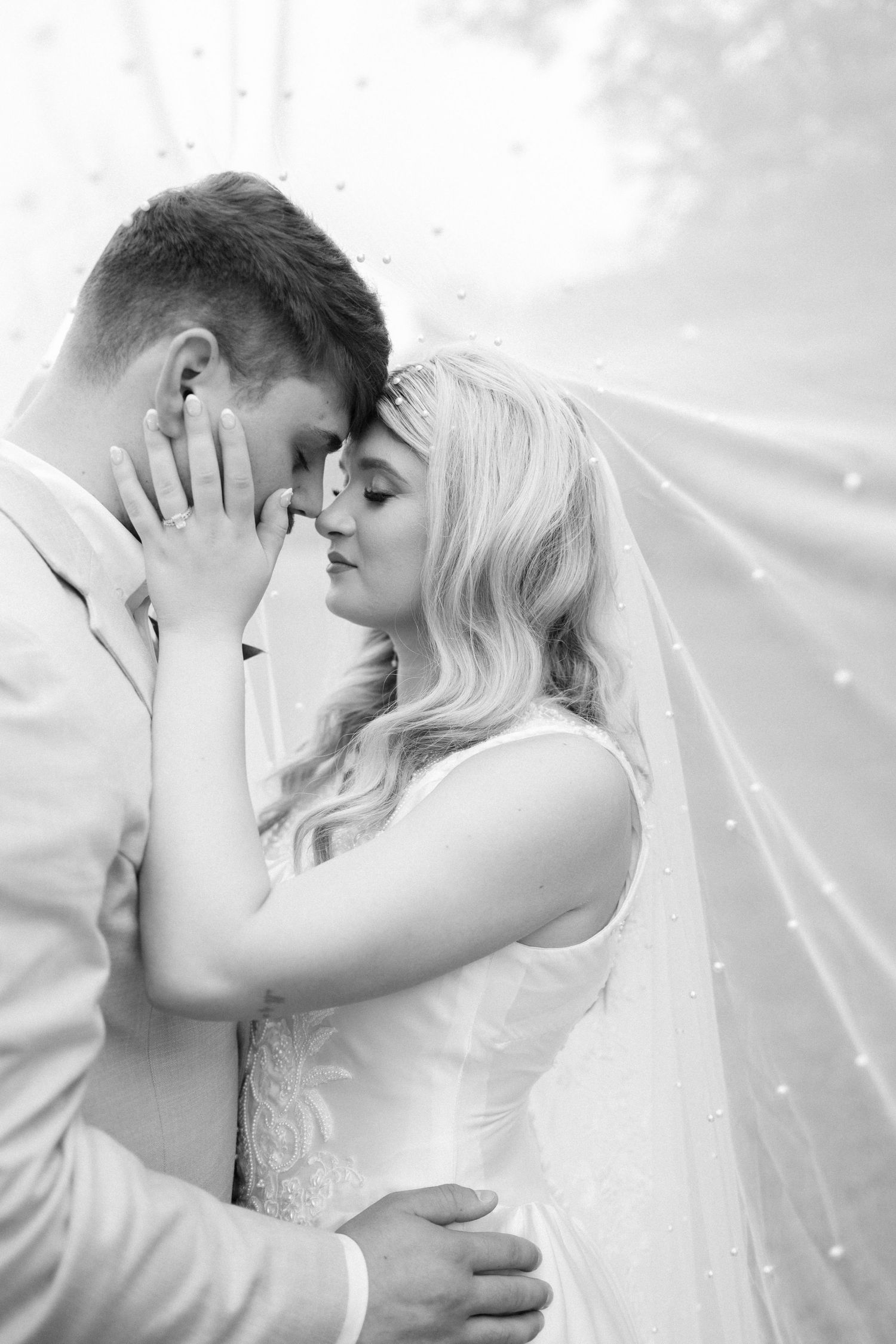 Intimate black and white wedding portraits showing tender moments between newlyweds.