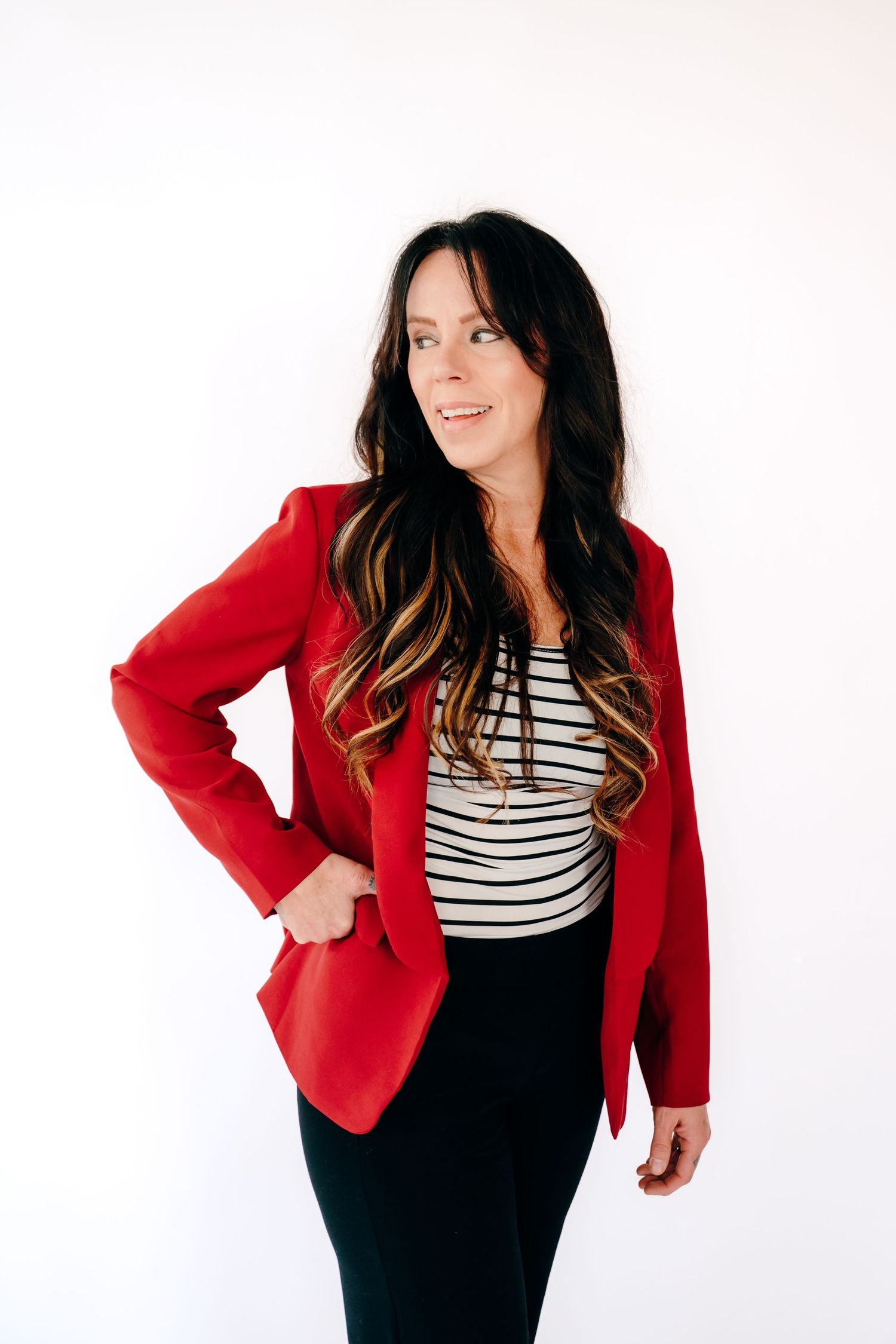 Woman in red blazer and striped shirt poses against white background in three similar fashion shots.