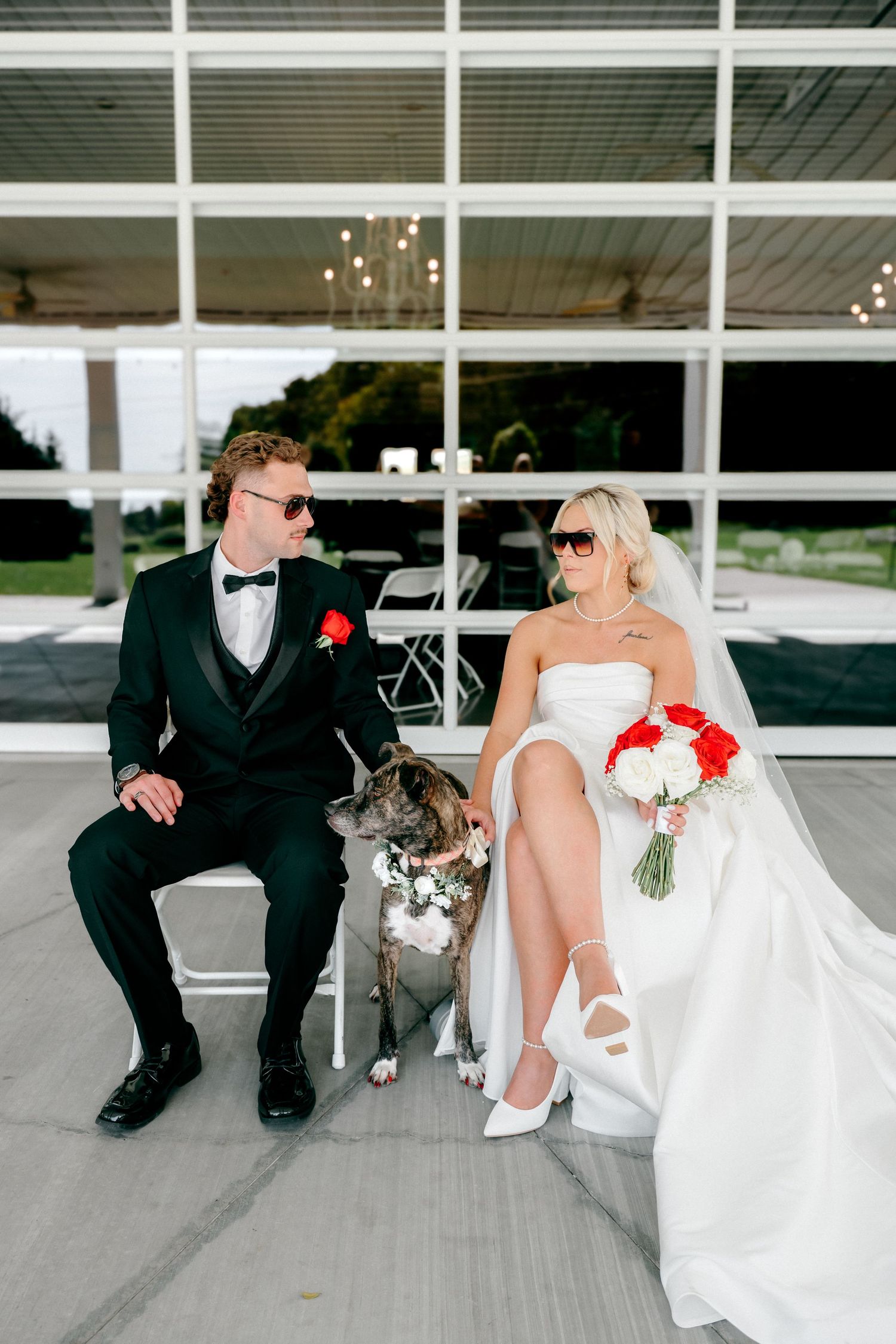 Bride and groom sit casually on a modern porch during their wedding photoshoot.