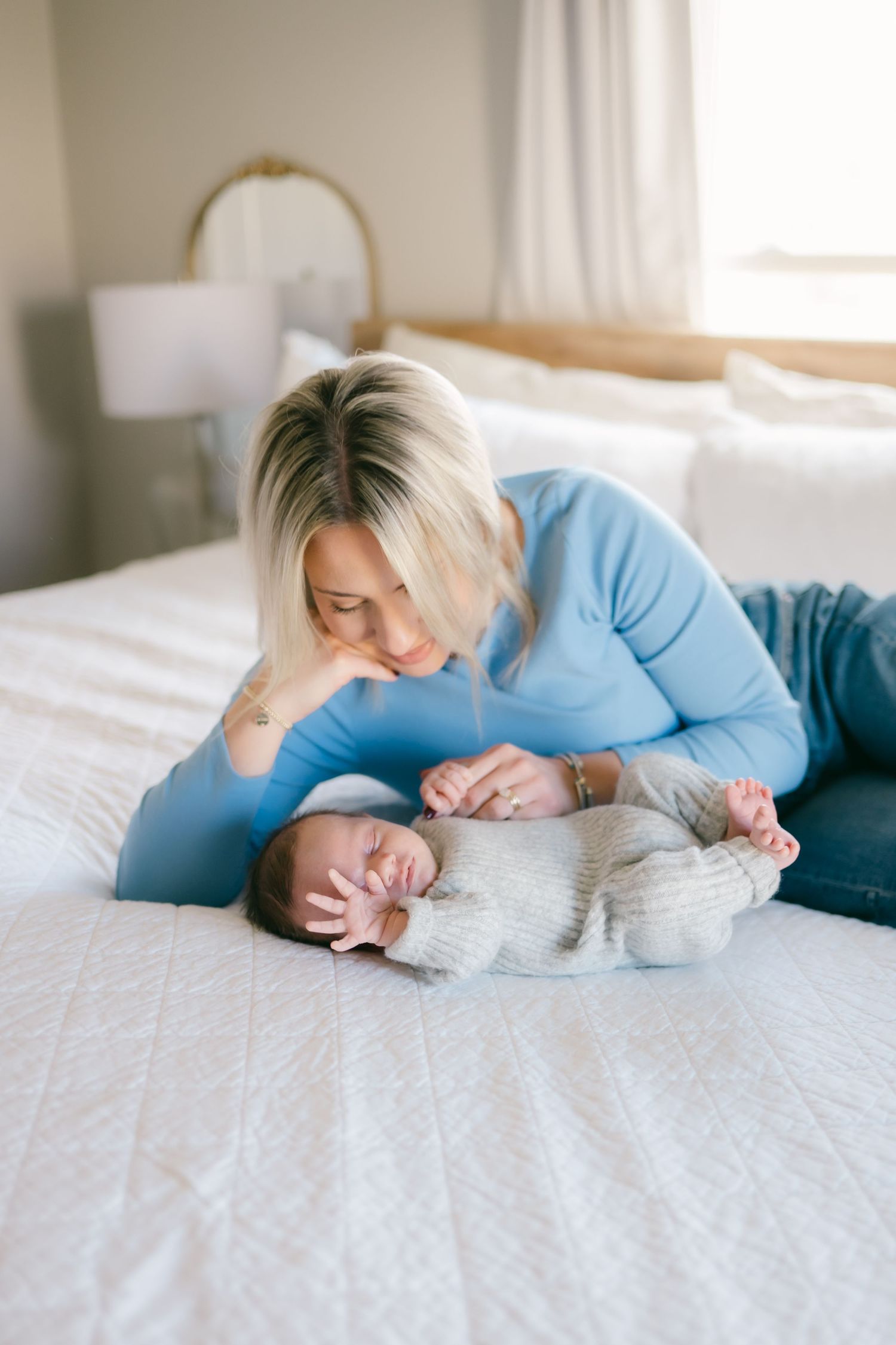 Tender moment between parent and baby on white bedding.